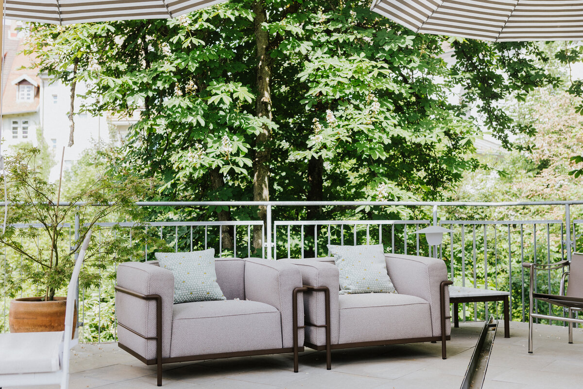 Zwei kompakte Outdoor-Sessel mit kleinen Beistelltischen in der Ausstellung von Seipp Wohnen