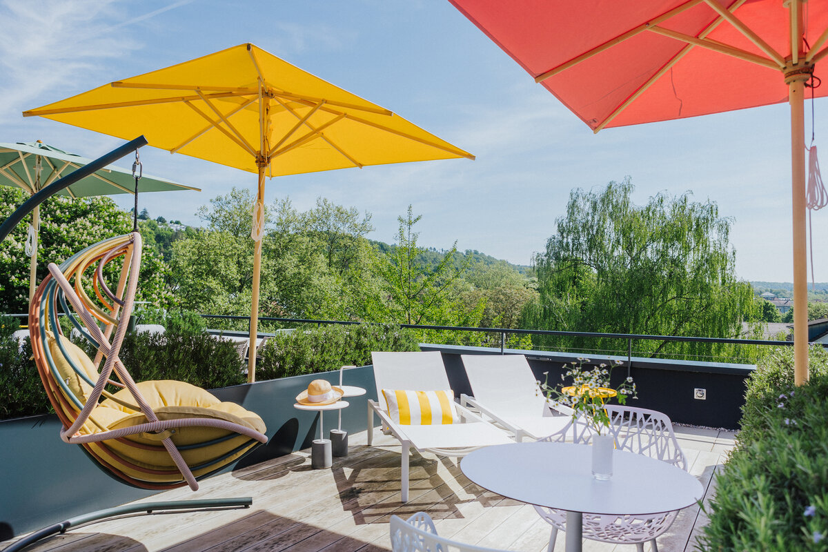 Gartenmöbel-Ausstellung auf der Dachterrasse in Tiengen mit farbigen Sonnenschirmen und Liegestühlen