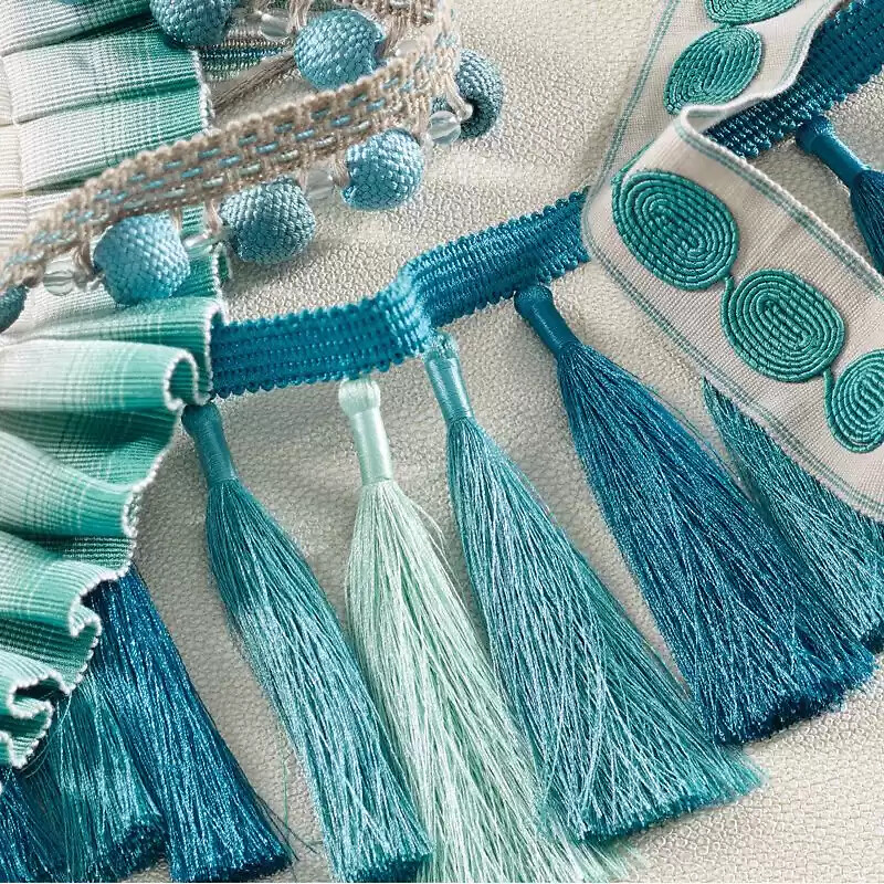 Nahaufnahme textiler Bordüren, Fransen und Zierbänder in Türkis von Osborne & Little