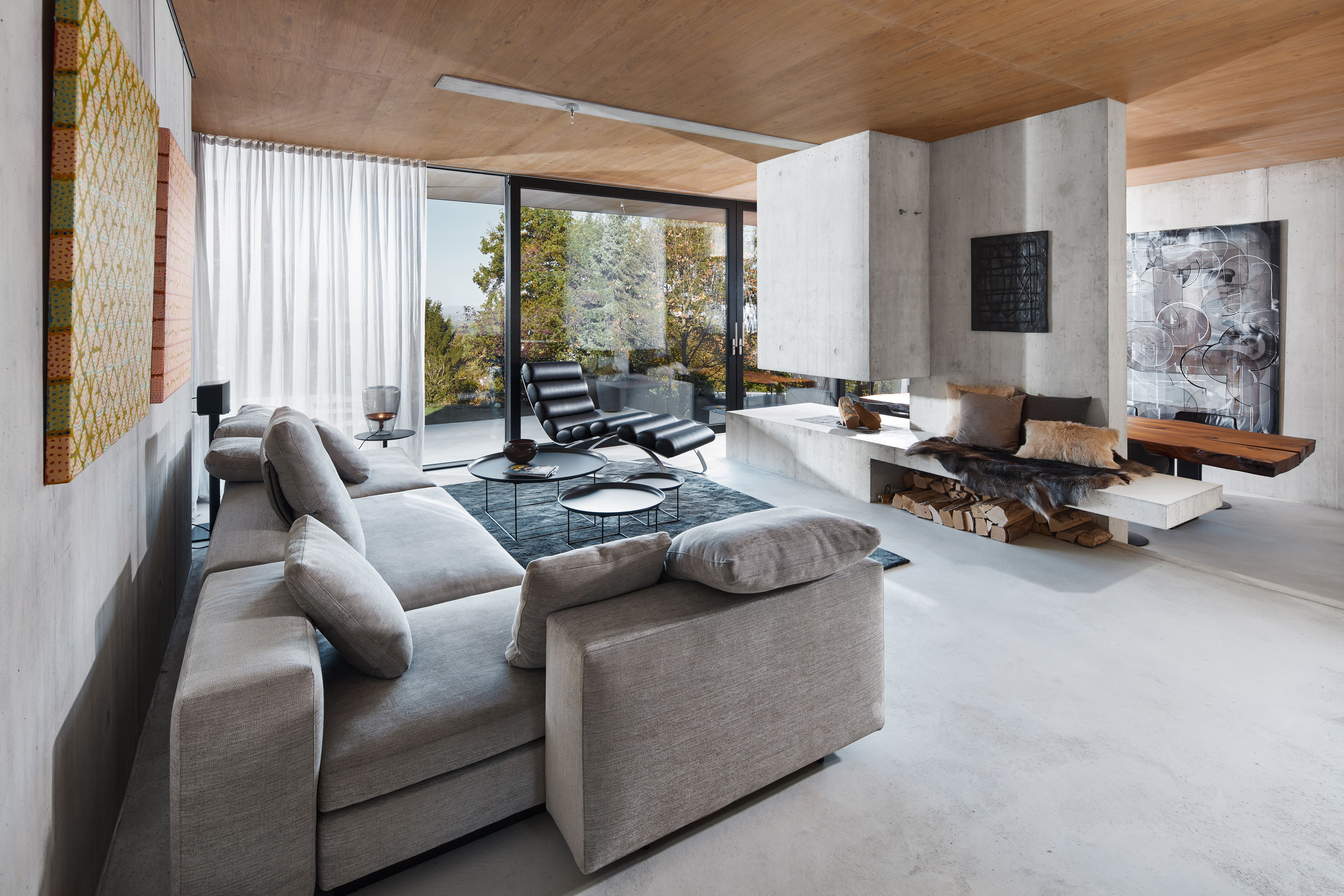 Beton, Holz und Glas bilden die Basis des modernen Neubaus. Mittelpunkt ist das offen gestaltete Erdgeschoss mit Wohn-, Koch- und Essbereich. Eine Besonderheit ist bereits von außen gut ersichtlich – das verbindende Element Eichenholz. Im Erdgeschoss zier