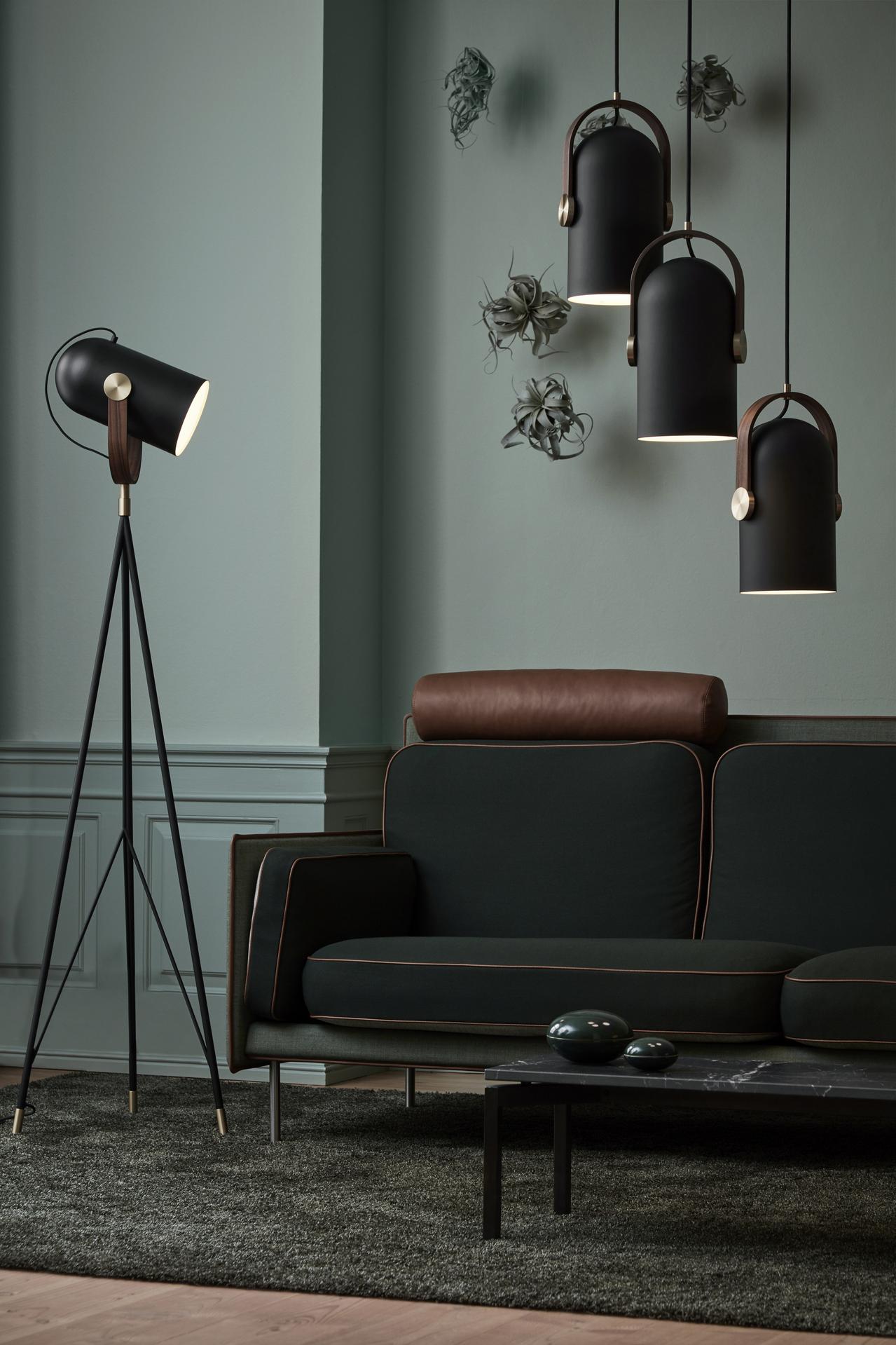 Dunkle Sitzecke mit schwarzen Le Klint Leuchten und wohnlicher Wandgestaltung