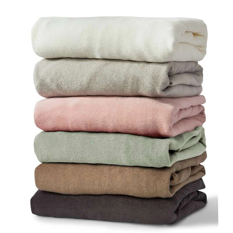 Gestapelte Spannbettlaken in sechs verschiedenen Farben auf weißem Hintergrund