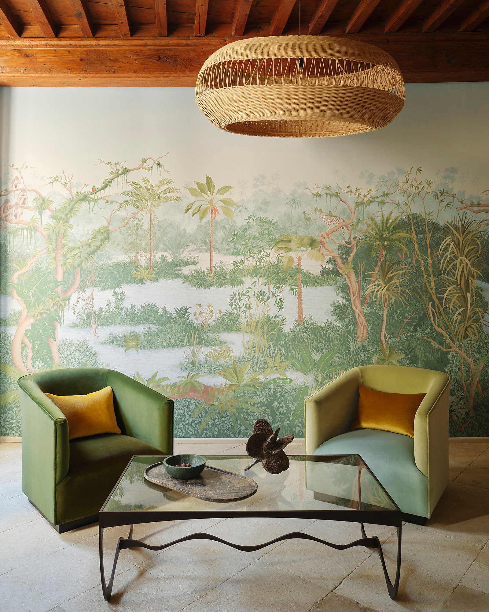 Großformatiger Wandbehang mit Palmendekor hinter grünem Sessel mit Zierkissen