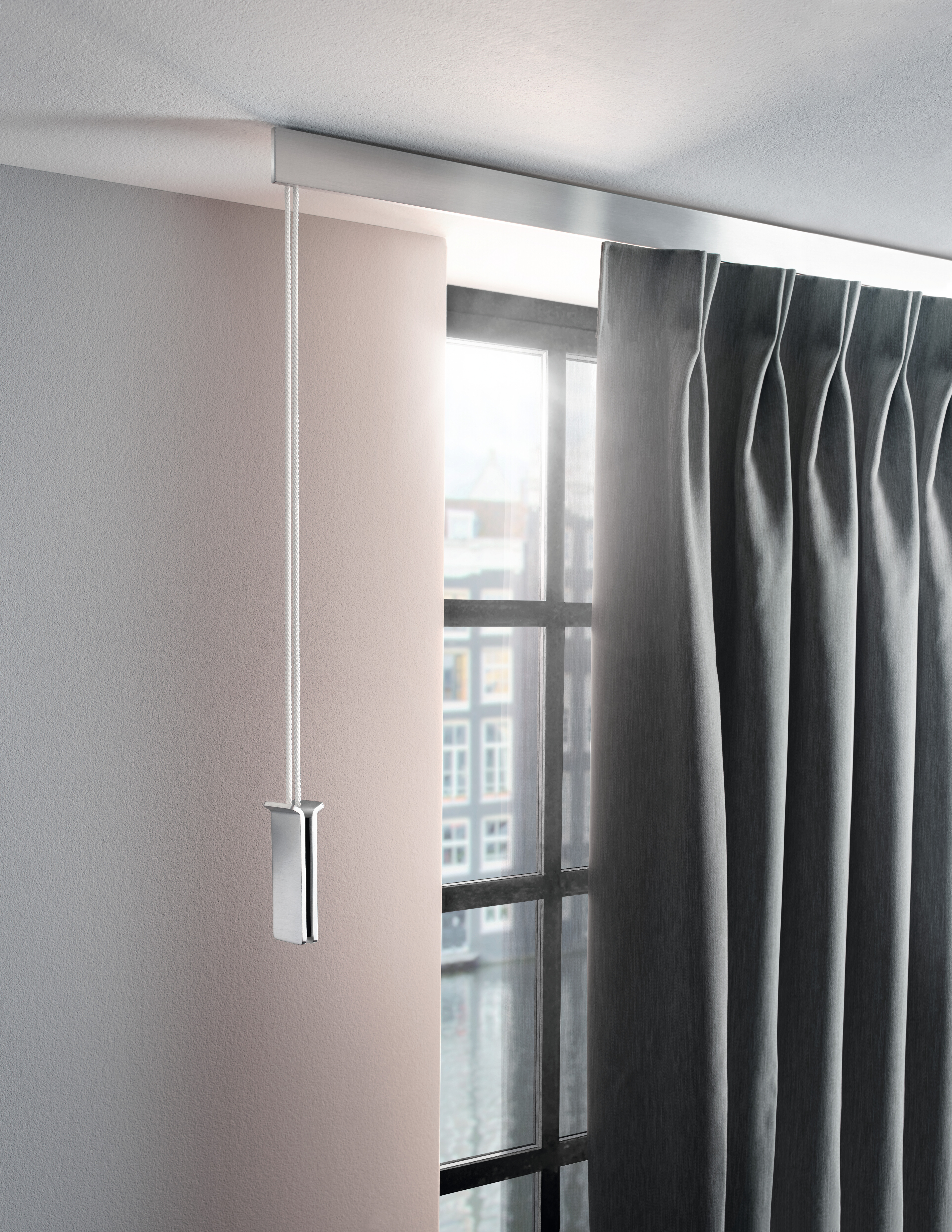 Grauer Vorhang mit Faltenband und Kordelzug an silberner Schiene vor Fensterfront