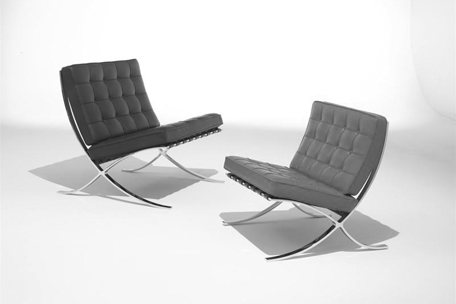 Zwei Barcelona Chairs von Ludwig Mies van der Rohe mit charakteristischem X-Fuß aus Chrom und schwarzem Leder.