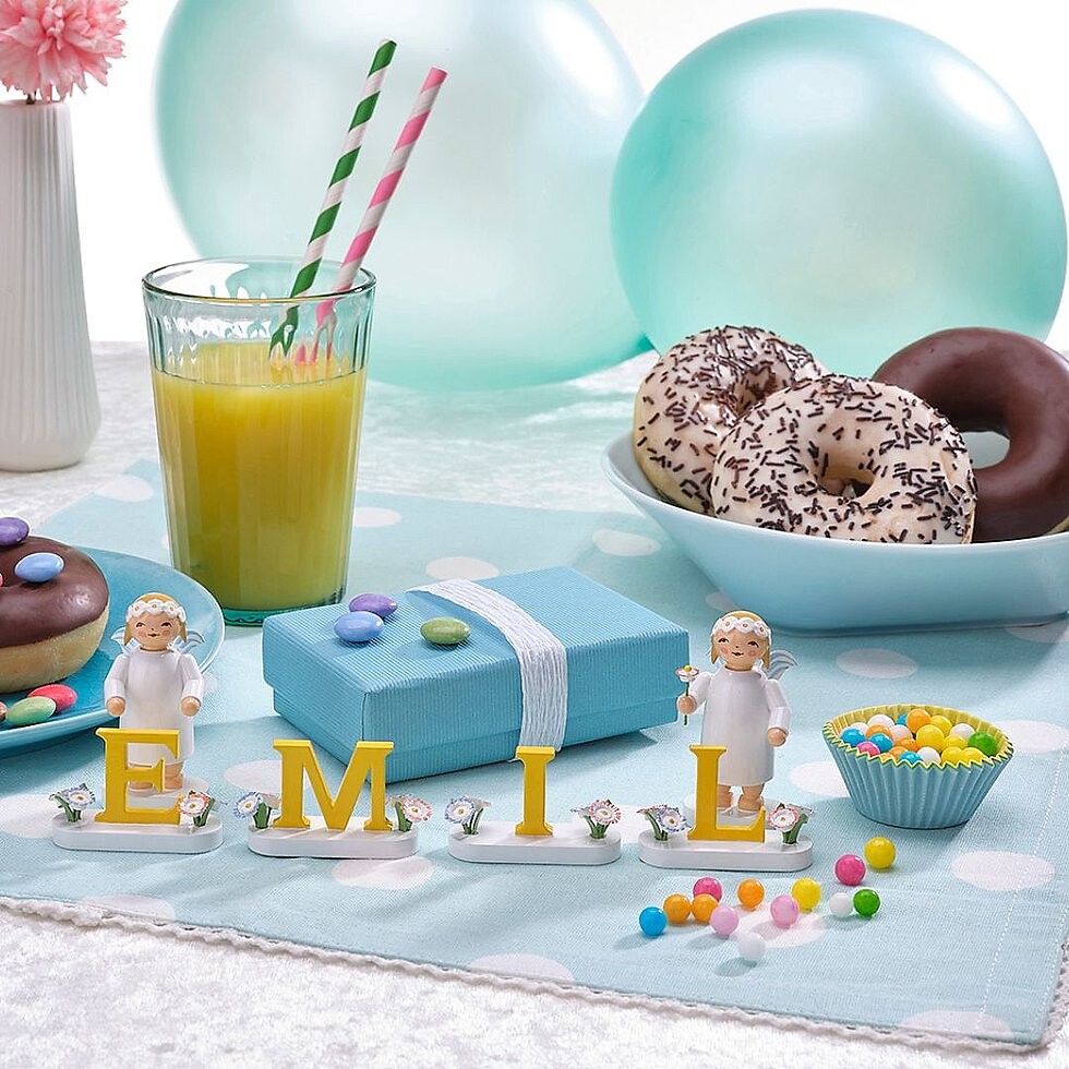 Engelfiguren mit Margeritenkopfschmuck auf Geburtstagstisch und Emil Schriftzug