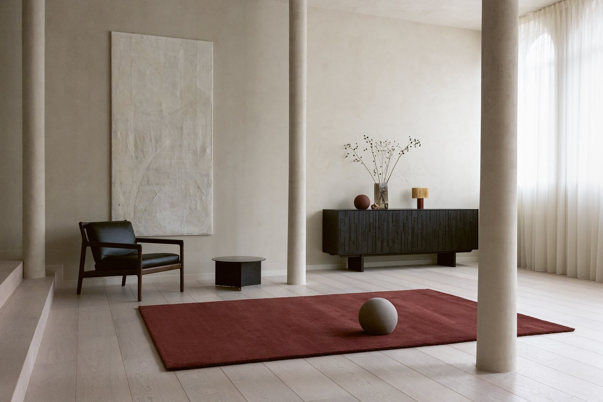 Roter Teppich von Longbarn mit Kugelobjekt in einem hellen, puristischen Raum