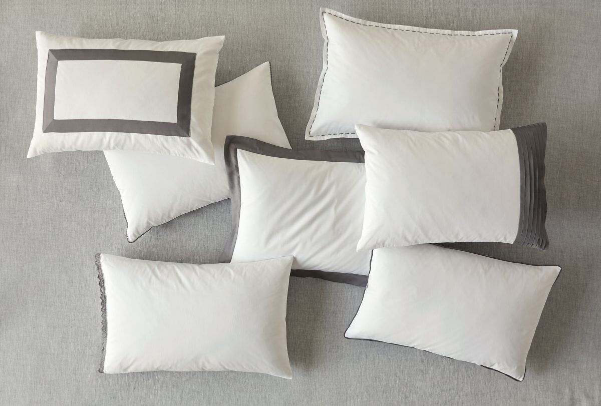 Auswahl an weißen Kissen auf heller Fläche