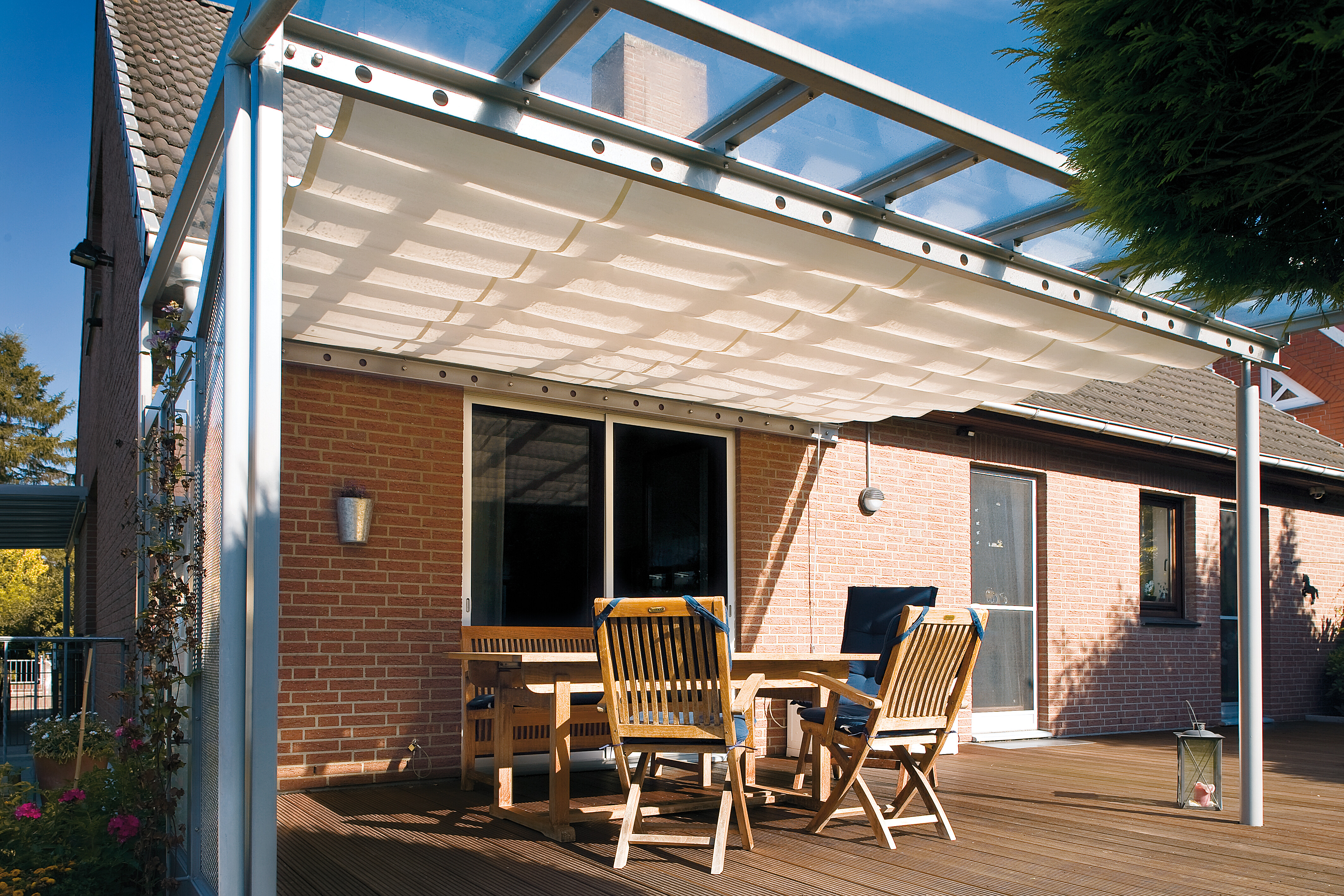 Pergola mit Stoffbespannung über Terrassenmöbeln und Holzdeck
