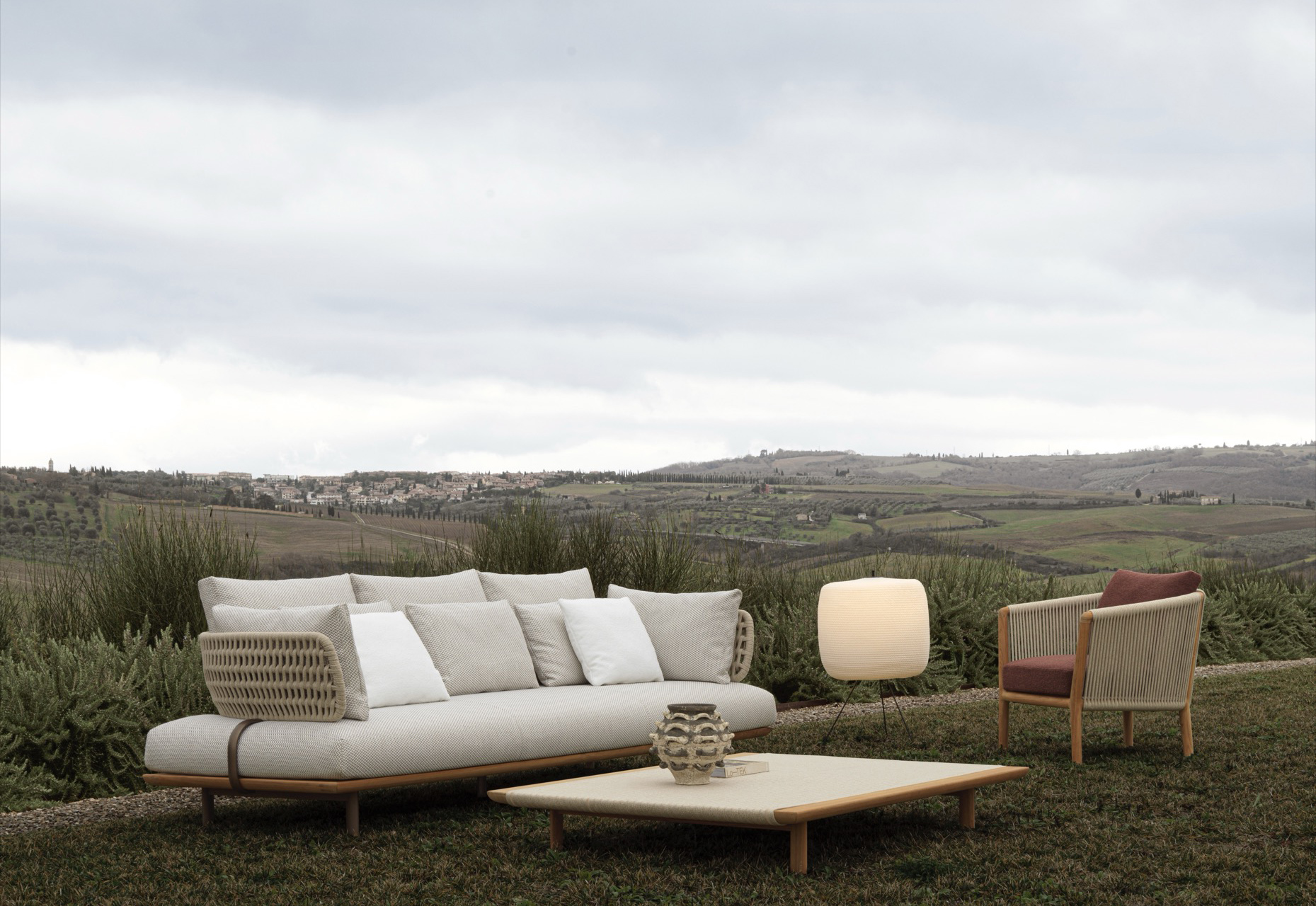 Molteni&C Sofa Sway mit Kissen, Lounge-Sessel und Tisch in offener Landschaft mit weitem Horizont