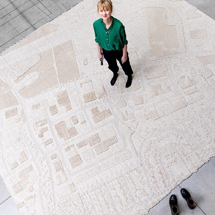 Teppich mit topografischem Muster, von oben fotografiert, Person steht im Zentrum