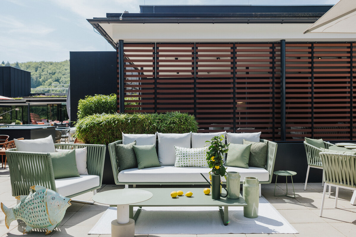 Moderne Outdoor-Sitzgruppe in sanften Grüntönen auf der Dachterrasse der Gartenmöbelausstellung Tiengen