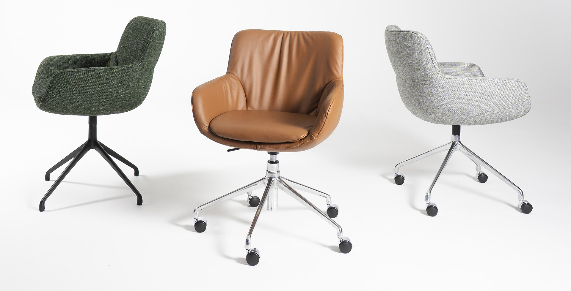 Drehbarer Sessel in Braun mit zwei weiteren gepolsterten Stühlen vor weißem Hintergrund