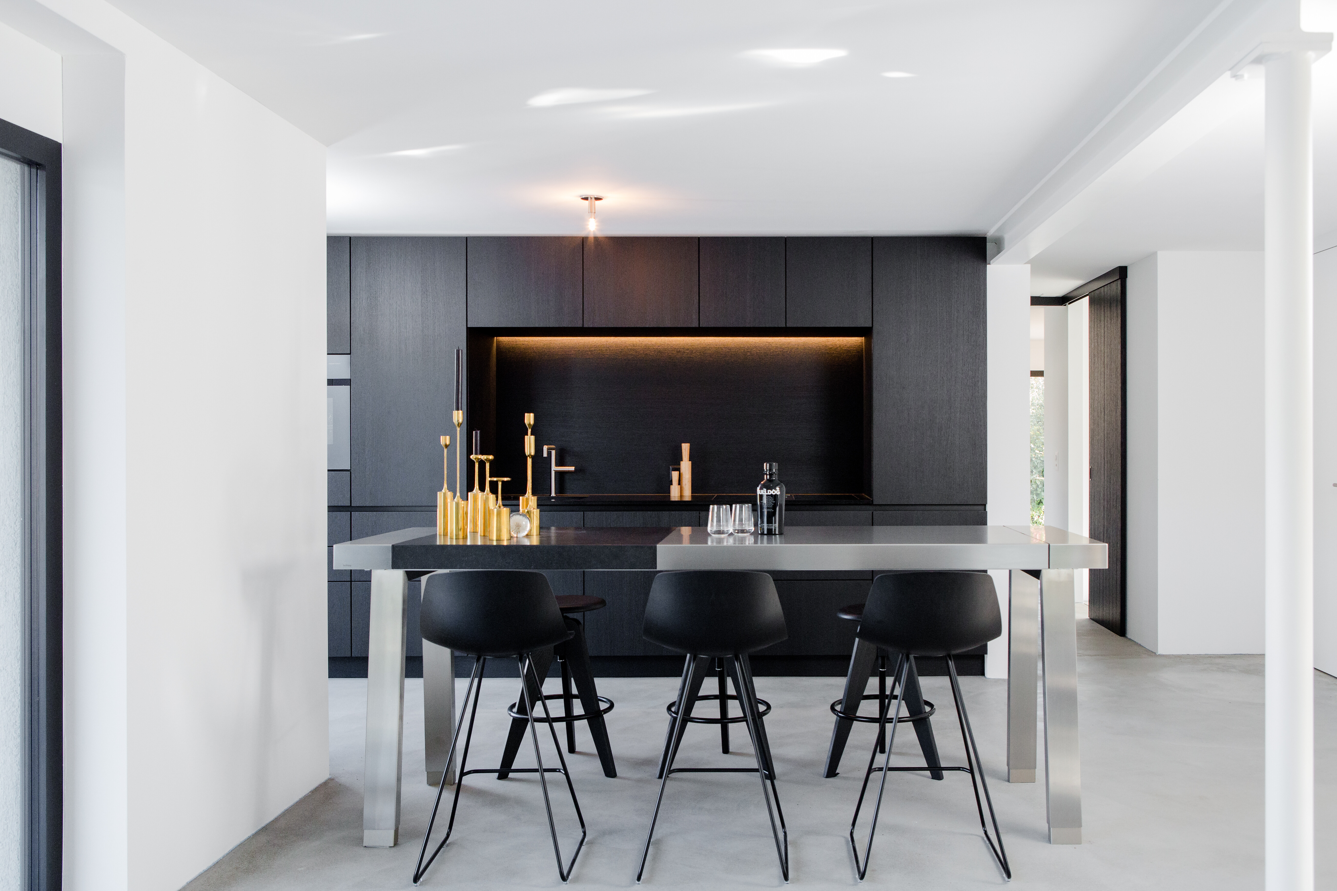 Die offene Wohnküche mit Essbereich, der mit der Werkbank von bulthaup als Esstisch ausgestattet ist.