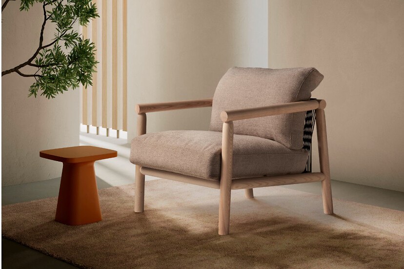 Loungesessel mit hellem Holzrahmen und beigem Bezug neben orangefarbenem Beistelltisch