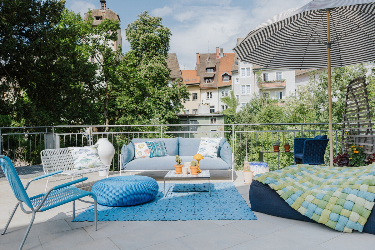 Outdoor-Ausstellung bei Seipp Wohnen in Waldshut mit Sitzmöbeln, Teppich und Sonnenschirm