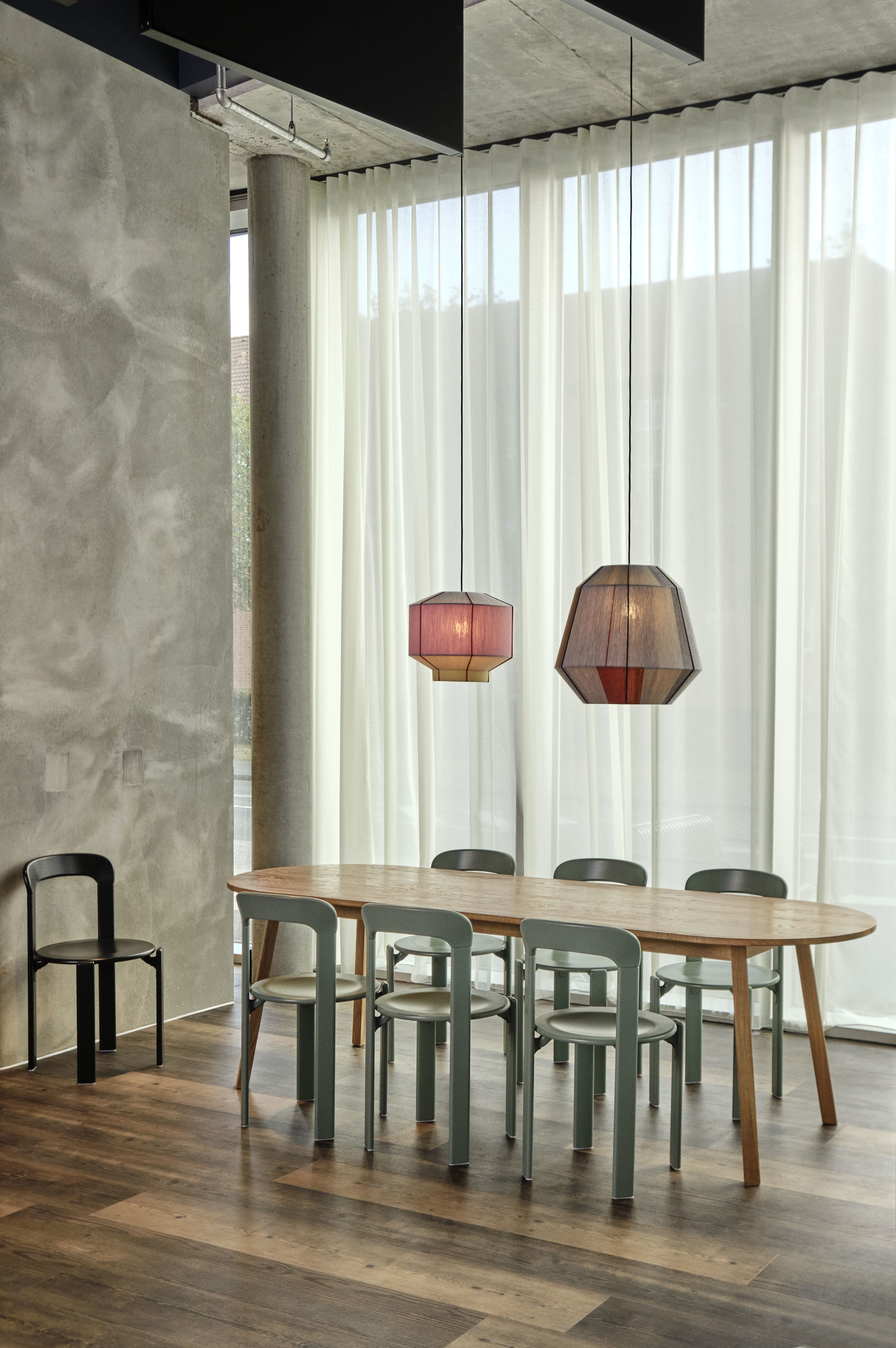 Ovaler Esstisch mit sechs Hay-Stühlen und zwei Pendelleuchten vor bodentiefer Gardine