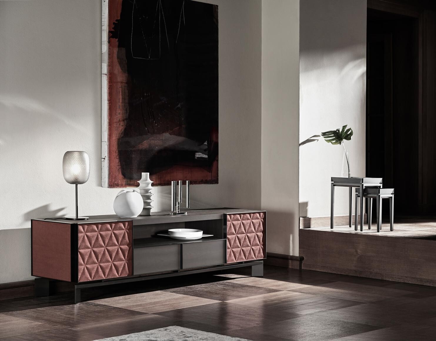 Sideboard mit geometrisch gemusterten Fronten vor heller Wand mit großformatigem Bild