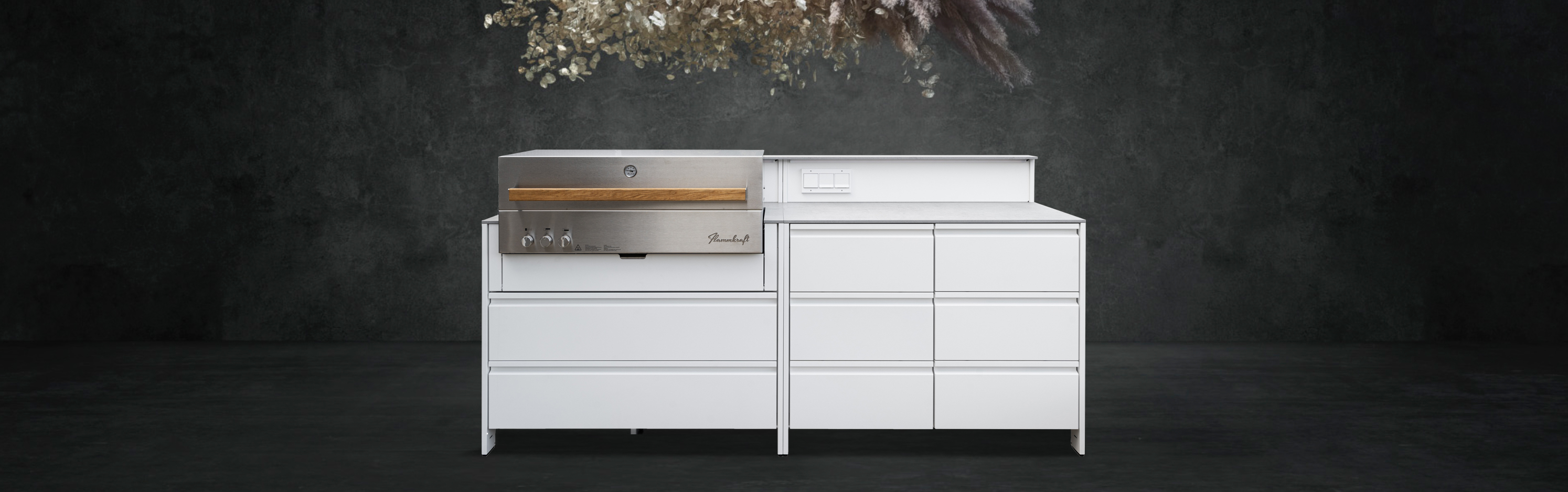 Belmento Outdoor-Küche mit integriertem Grillmodul vor dunkler Wandkulisse. Klare Linienführung und wetterfeste Materialien für außen.