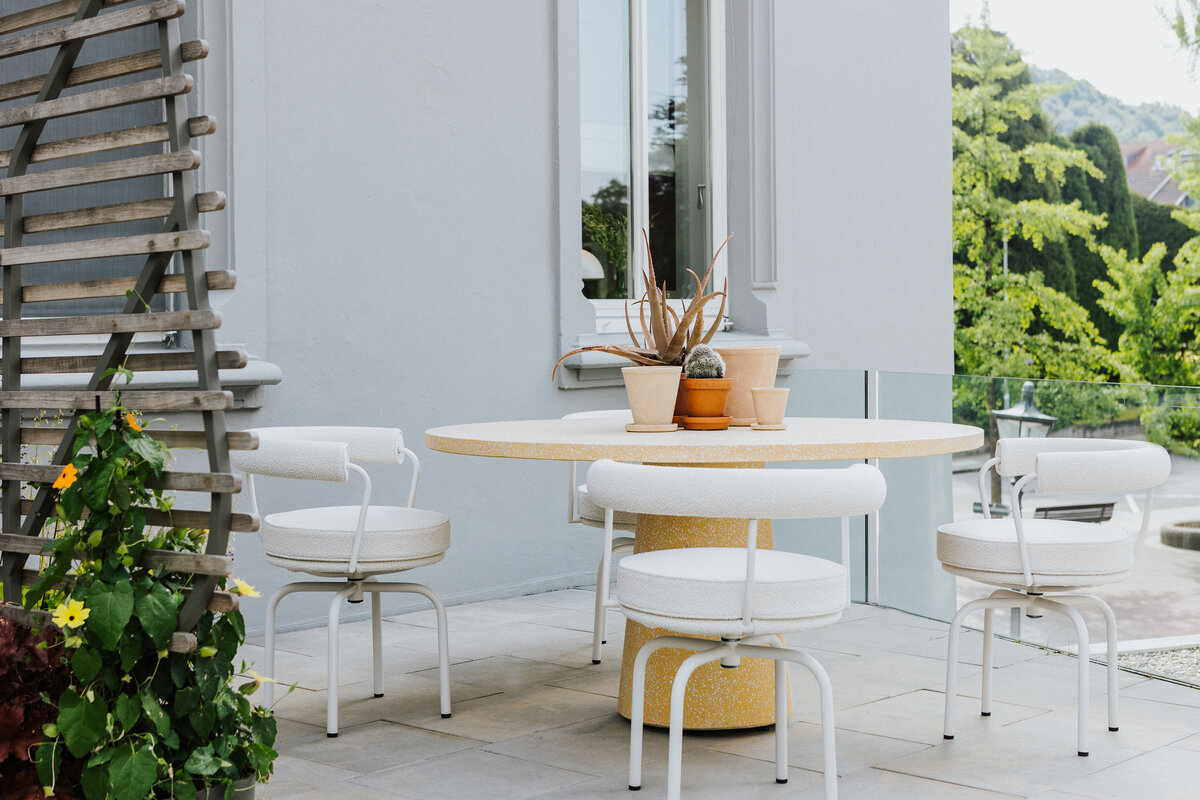 Runder Outdoor-Tisch mit vier weißen Sesseln auf der Terrasse der Ausstellung Seipp Wohnen in Waldshut