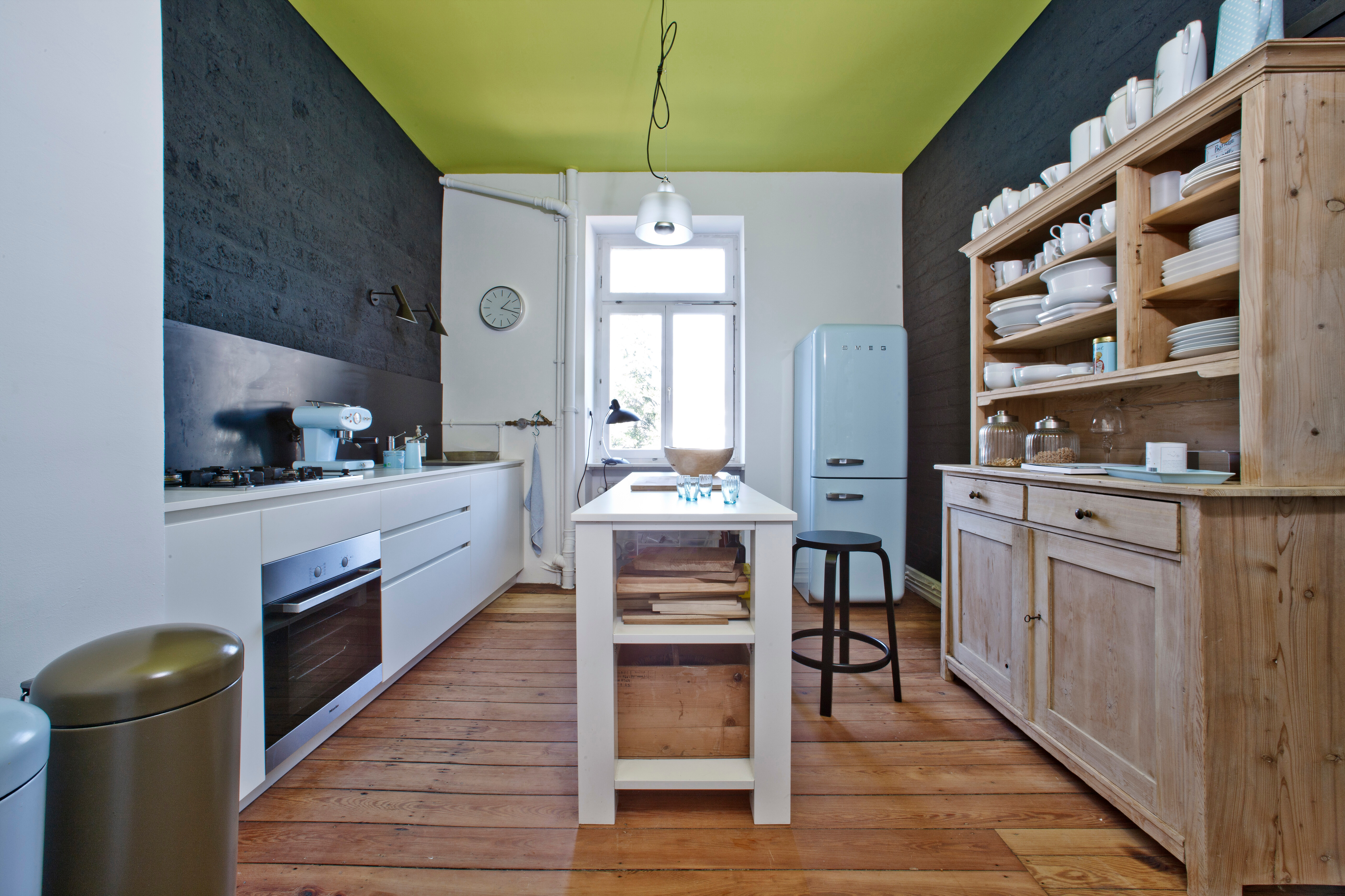 Elemente verschiedener Stilrichtungen vereinen sich zu einem spannenden Mix. Einbauküche von Varenna, Standkühlschrank von Smeg.