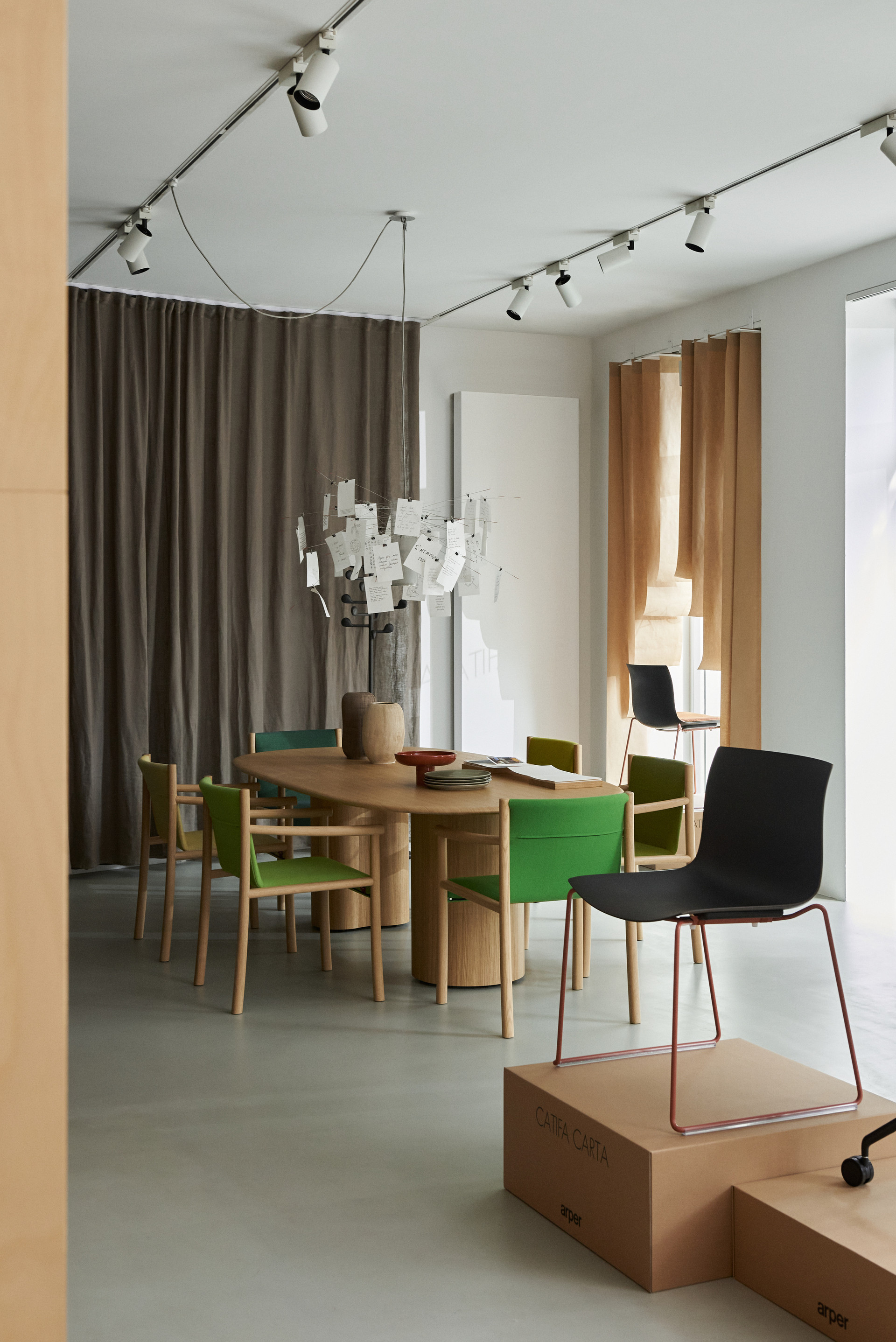 Stuhlgruppe mit schwarzen und grünen Stühlen um einen großen Holztisch