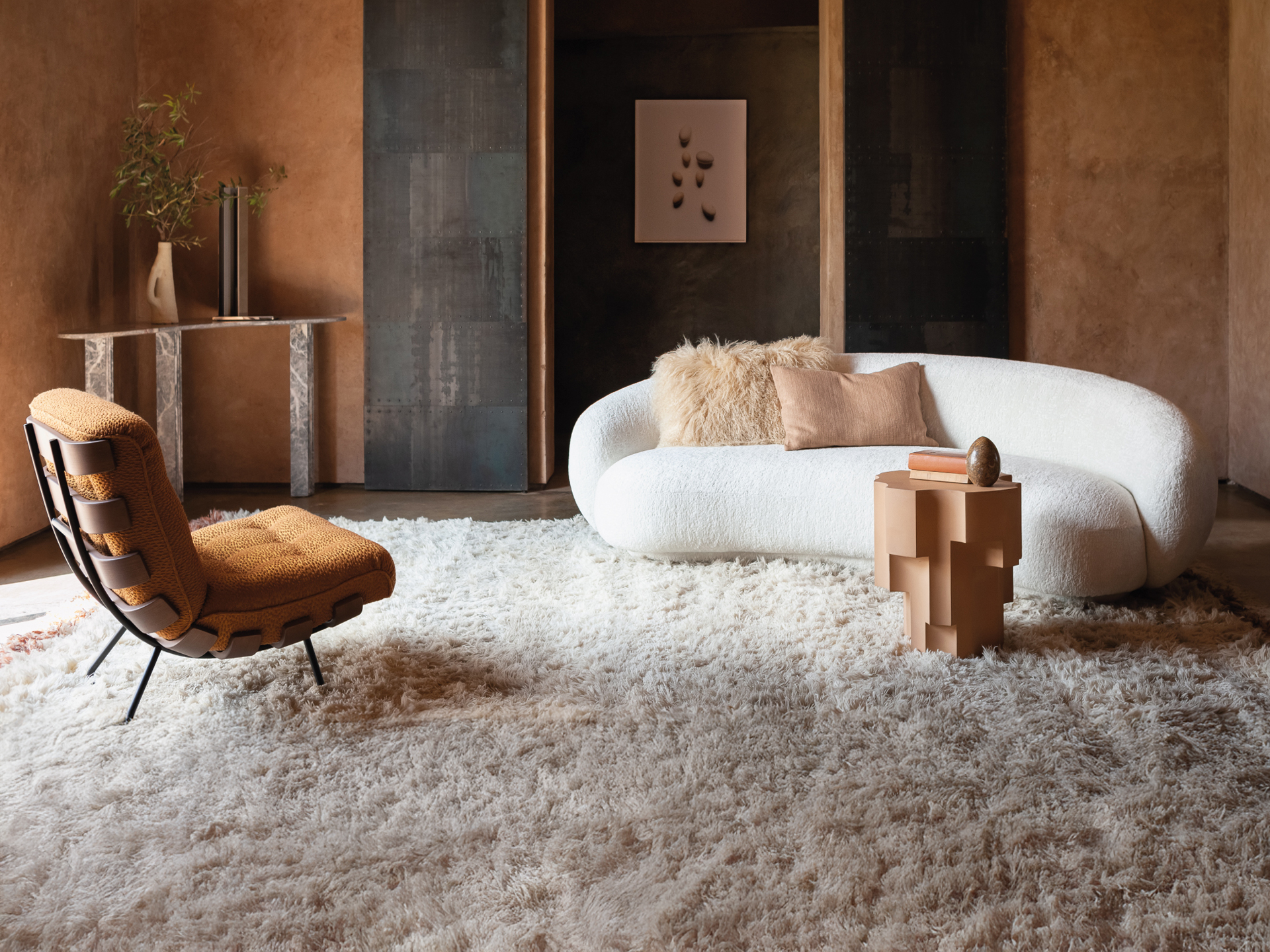 Sofa mit geschwungener Silhouette und weichem Bezug auf hellem Teppich