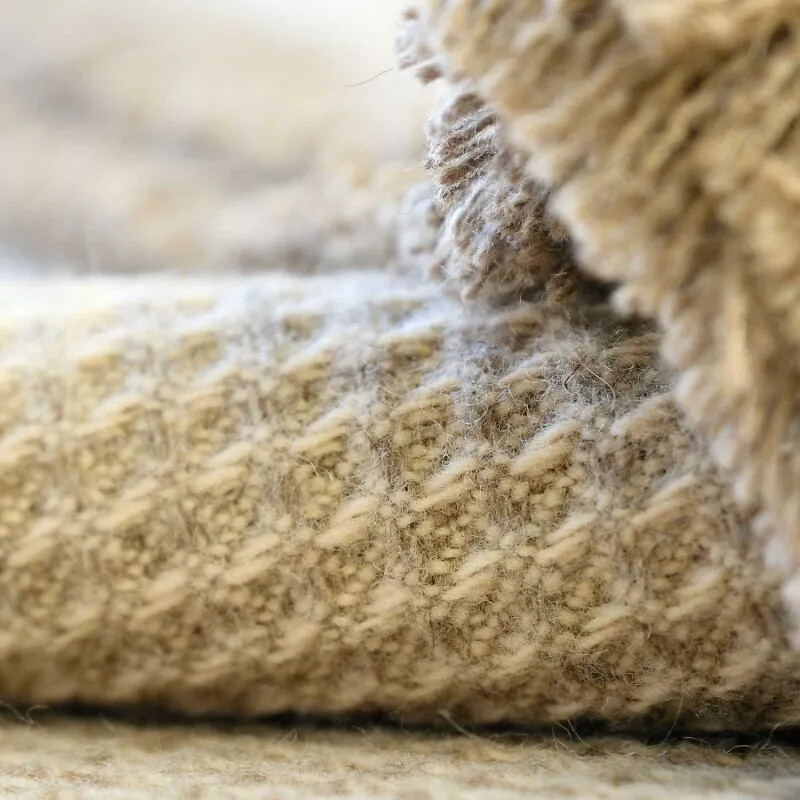 Nahaufnahme einer naturfarbenen Wolldecke mit feiner, weicher Textur