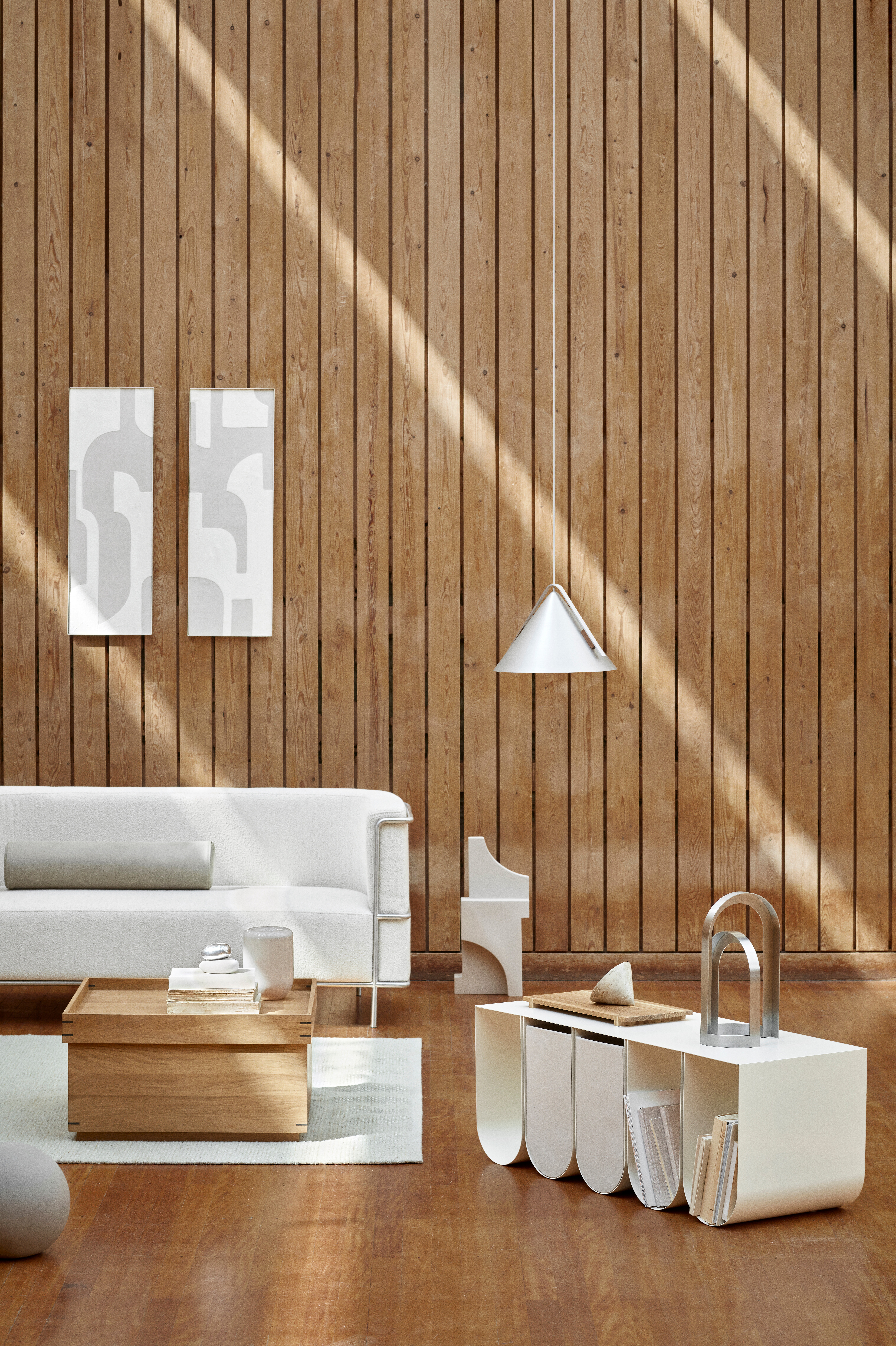 Wohnzimmer mit Holzvertäfelung, weißen Möbeln und grafischen Wandobjekten