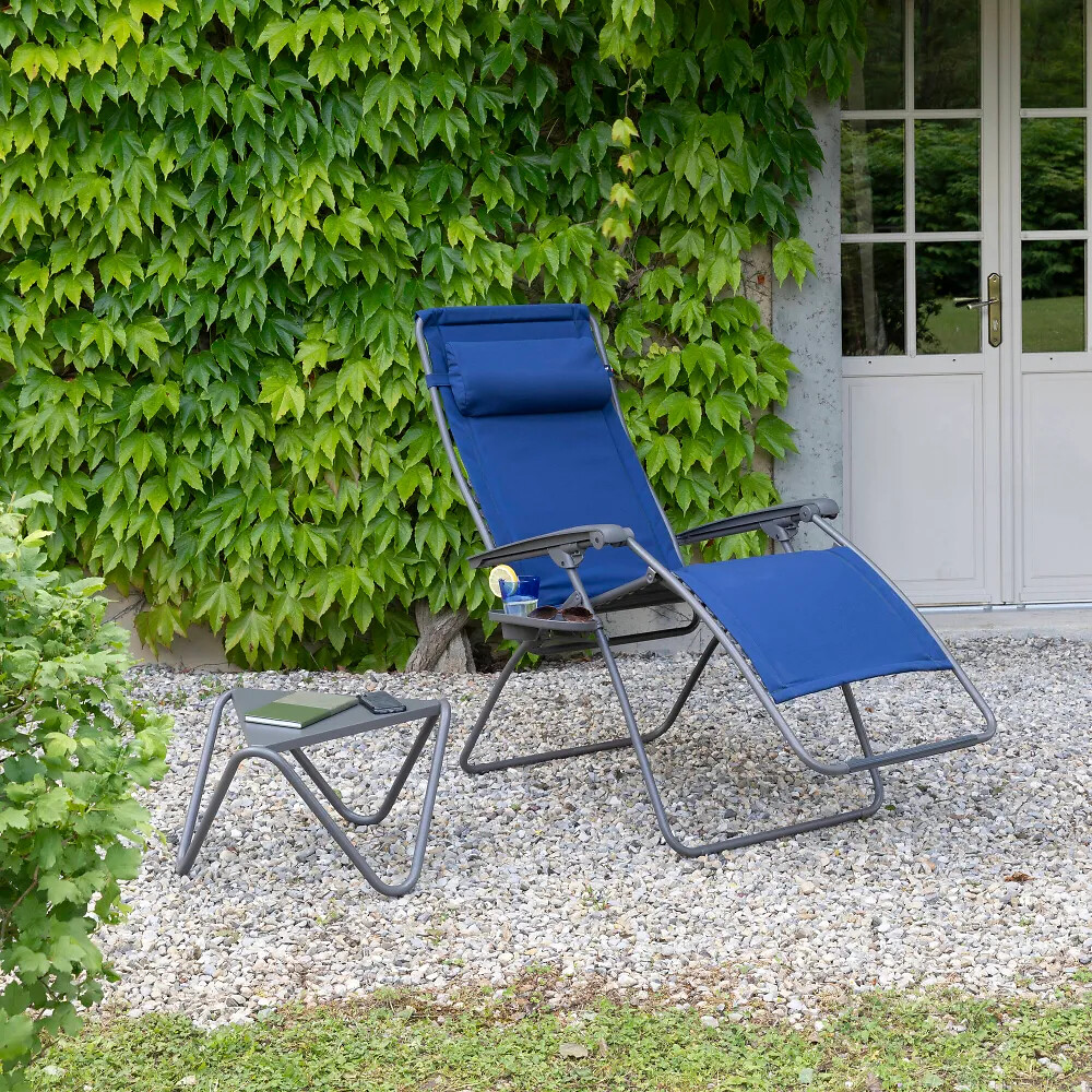 Relaxsessel in Blau mit passender Fußstütze auf Kiesfläche