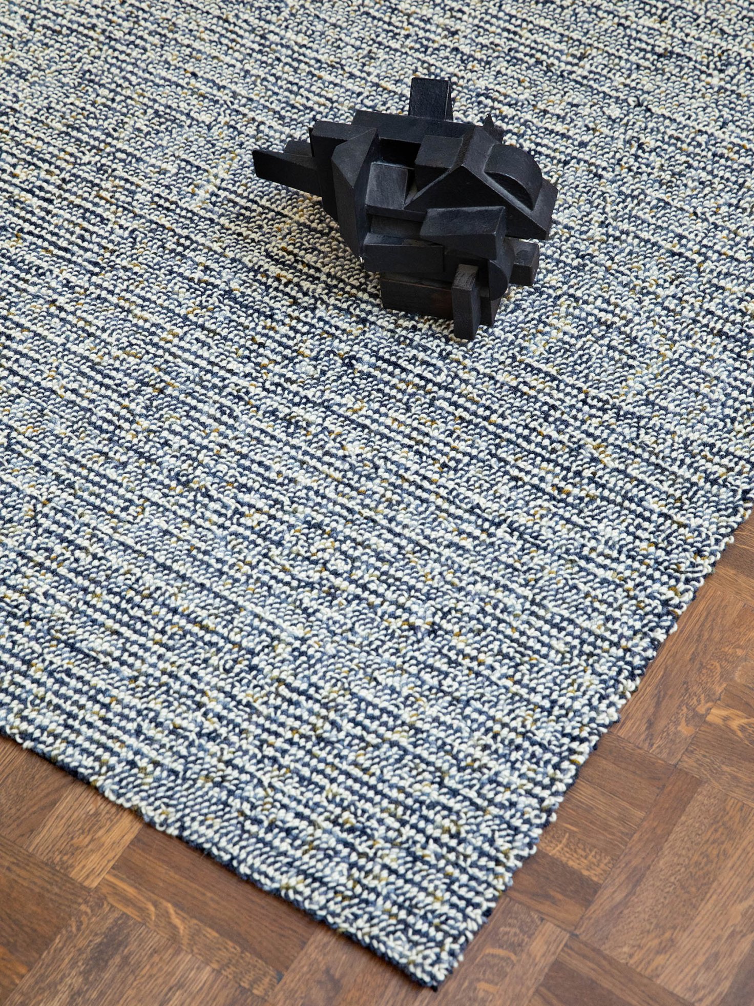 Nahaufnahme eines melierten Teppichs mit grafischem Objekt in Schwarz