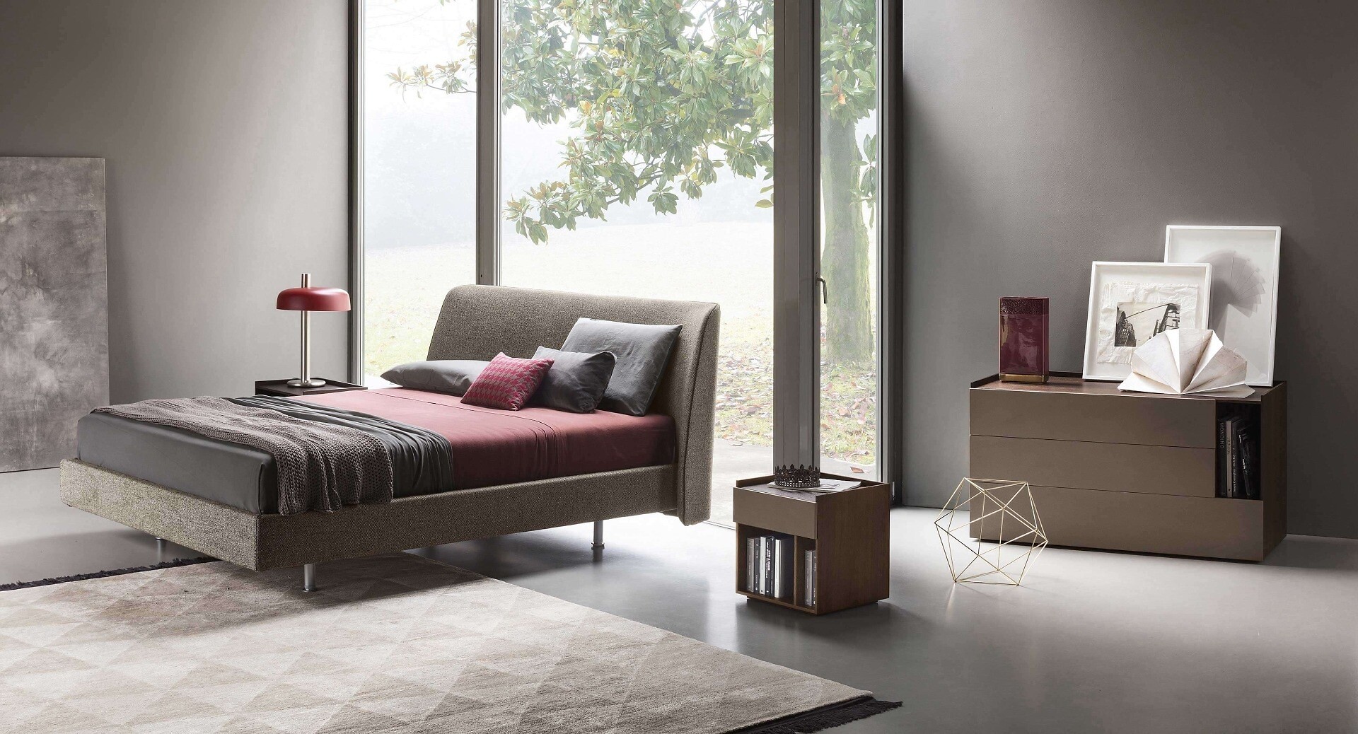 Modernes Schlafzimmer mit gepolstertem Bett, Tagesdecke, Sideboard und geometrischem Objekt