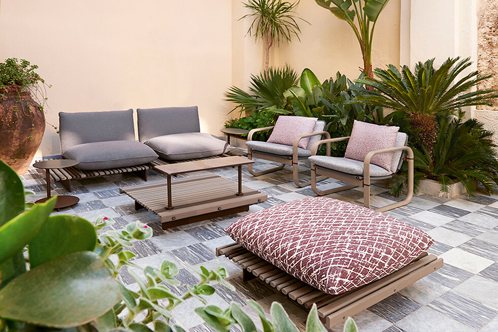 Outdoor-Möbel mit Loungesesseln, Bank und Bodenkissen auf gefliestem Patio