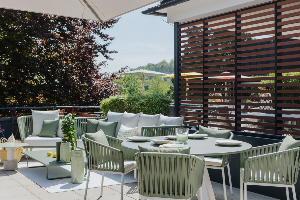 Essplatz und Lounge-Sofa mit hellgrünen Outdoor-Möbeln auf der Dachterrasse der Ausstellung Tiengen