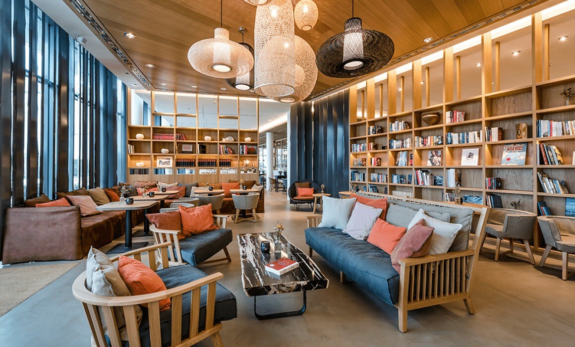 Loungebereich mit Holzsofas, Kissen und verschiedenen Hängeleuchten