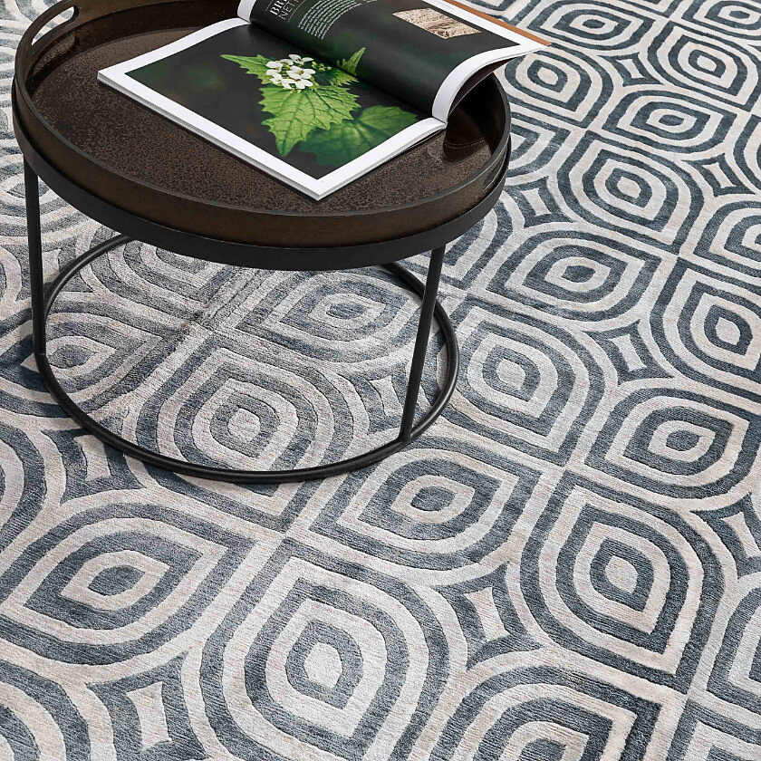 Geometrisch gemusterter Teppich in Schwarz-Weiß mit runder Ablage