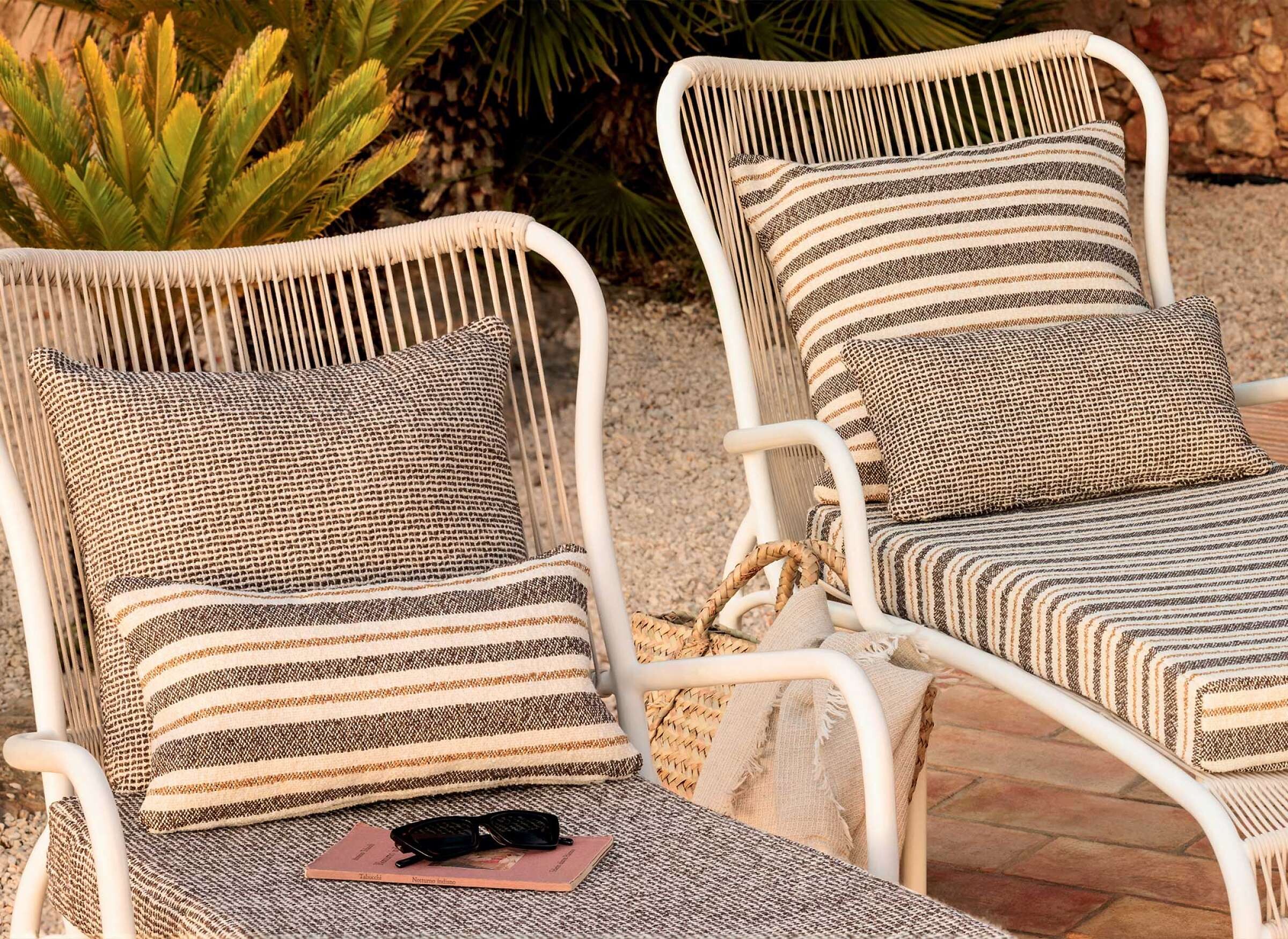 Zwei Sonnenliegen mit Outdoor-Stoffen in Streifen- und Punktmuster in neutralen Tönen auf Terrasse