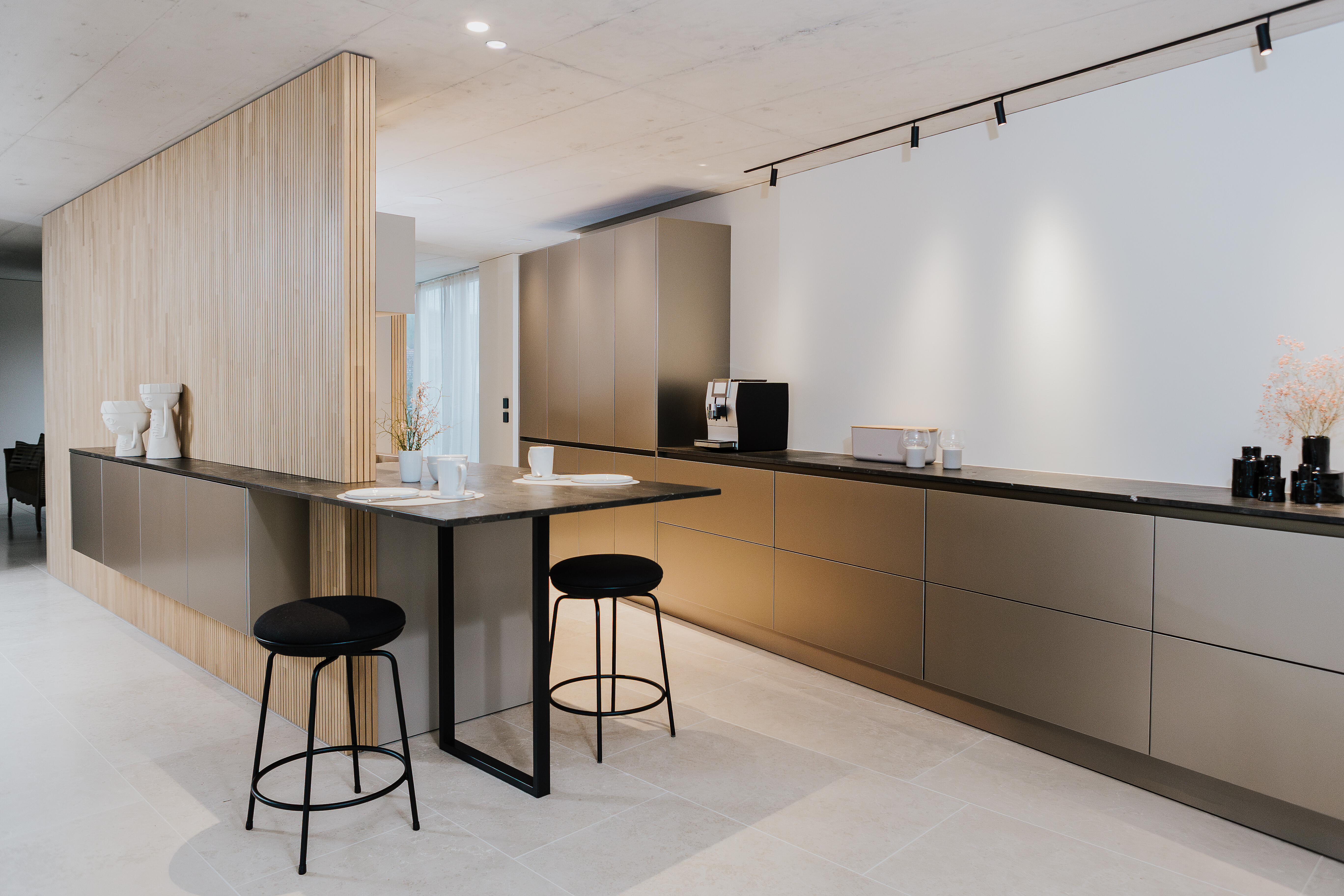 Moderne Küche mit mattgrauen Fronten, filigraner Theke und Rückwand aus senkrechtem Holzdekor.