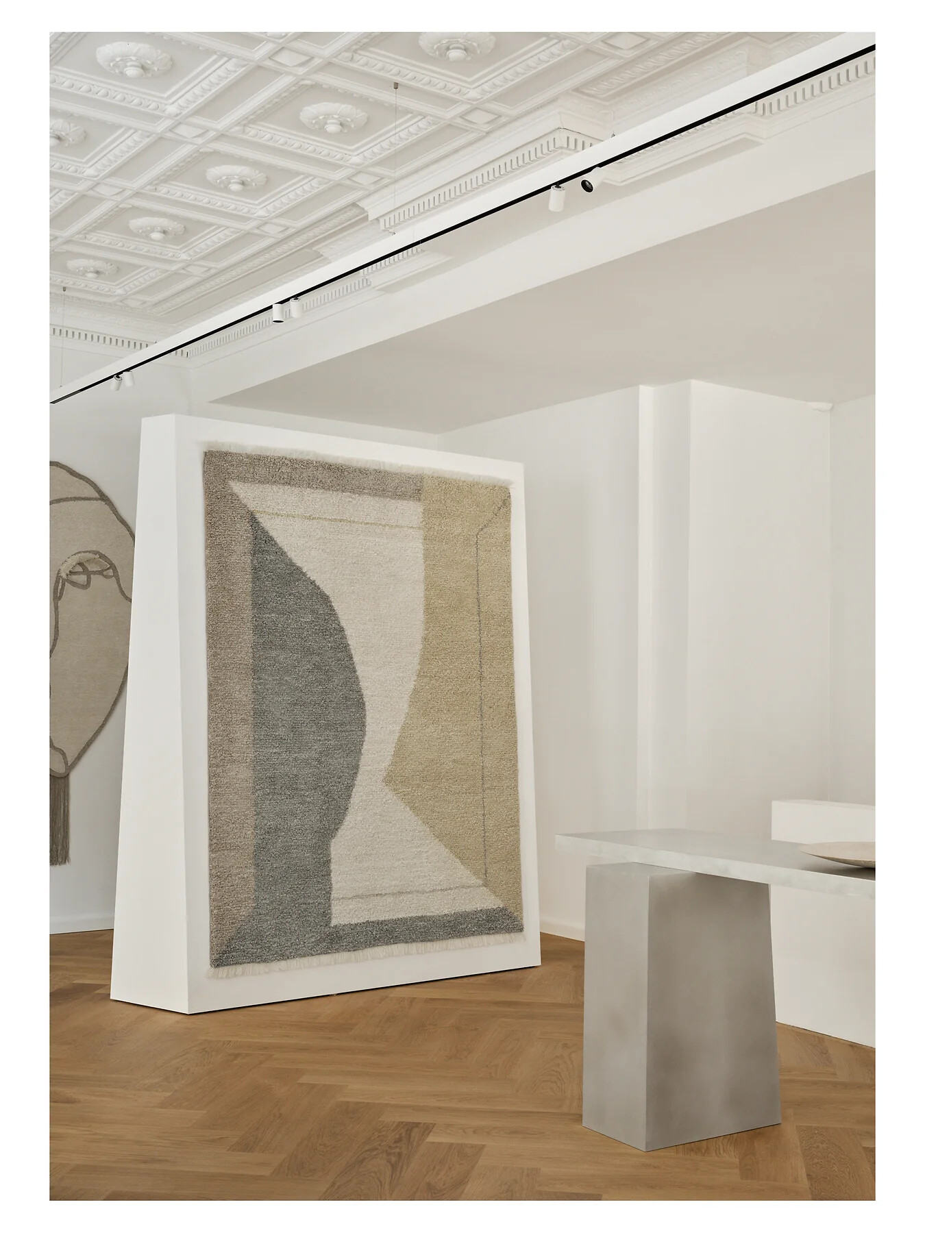 Abstrakt gewebter Teppich, stehend in einer weißen Galerieraum-Nische