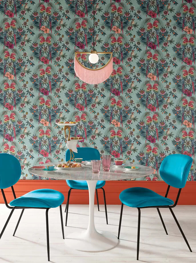 Wandtapete mit floralem Muster in Türkis und Pink hinter Esstisch mit blauen Stühlen