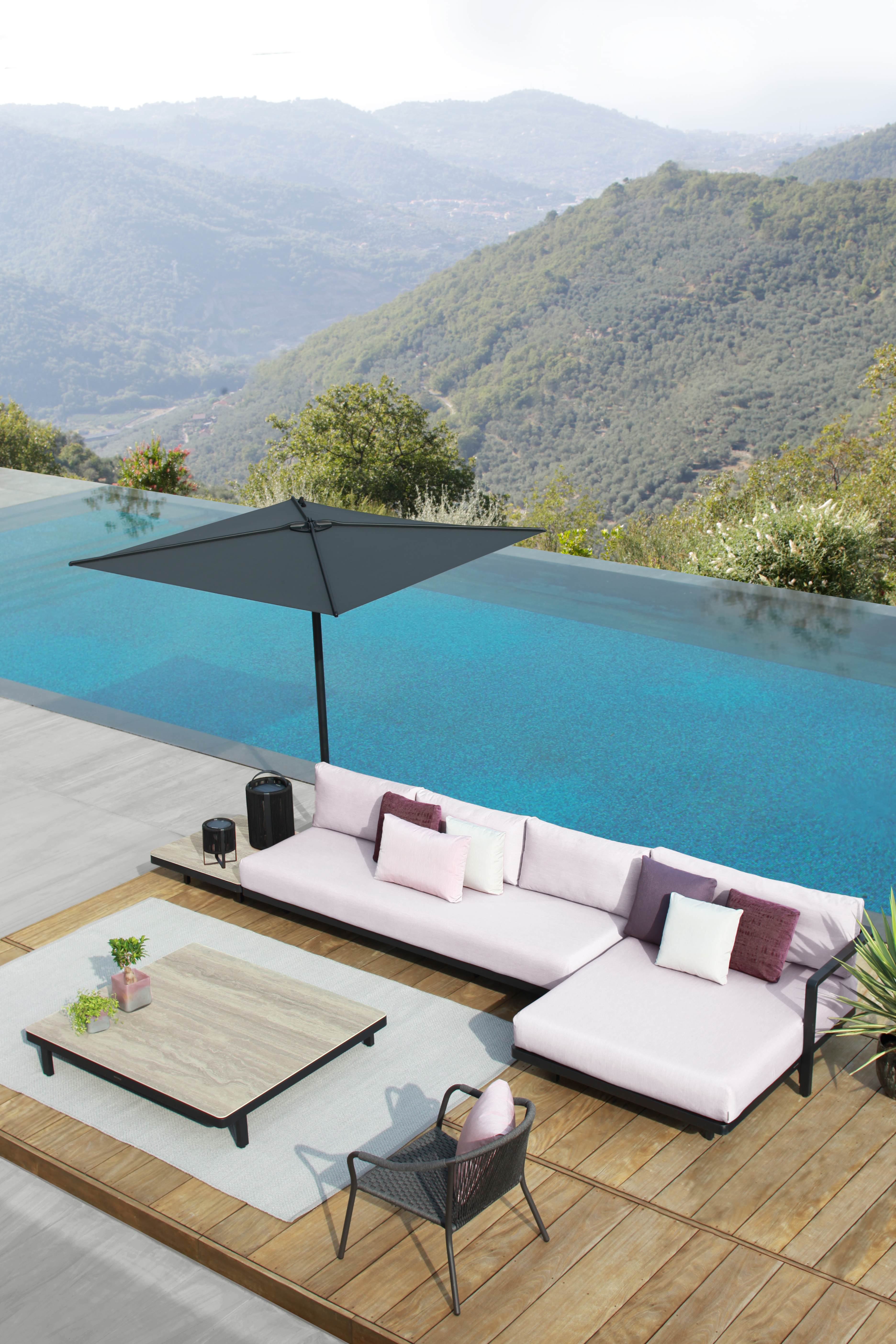 Lounge-Ensemble mit Alura Sofa, hellem Bezug und Low Chair am Infinity-Pool