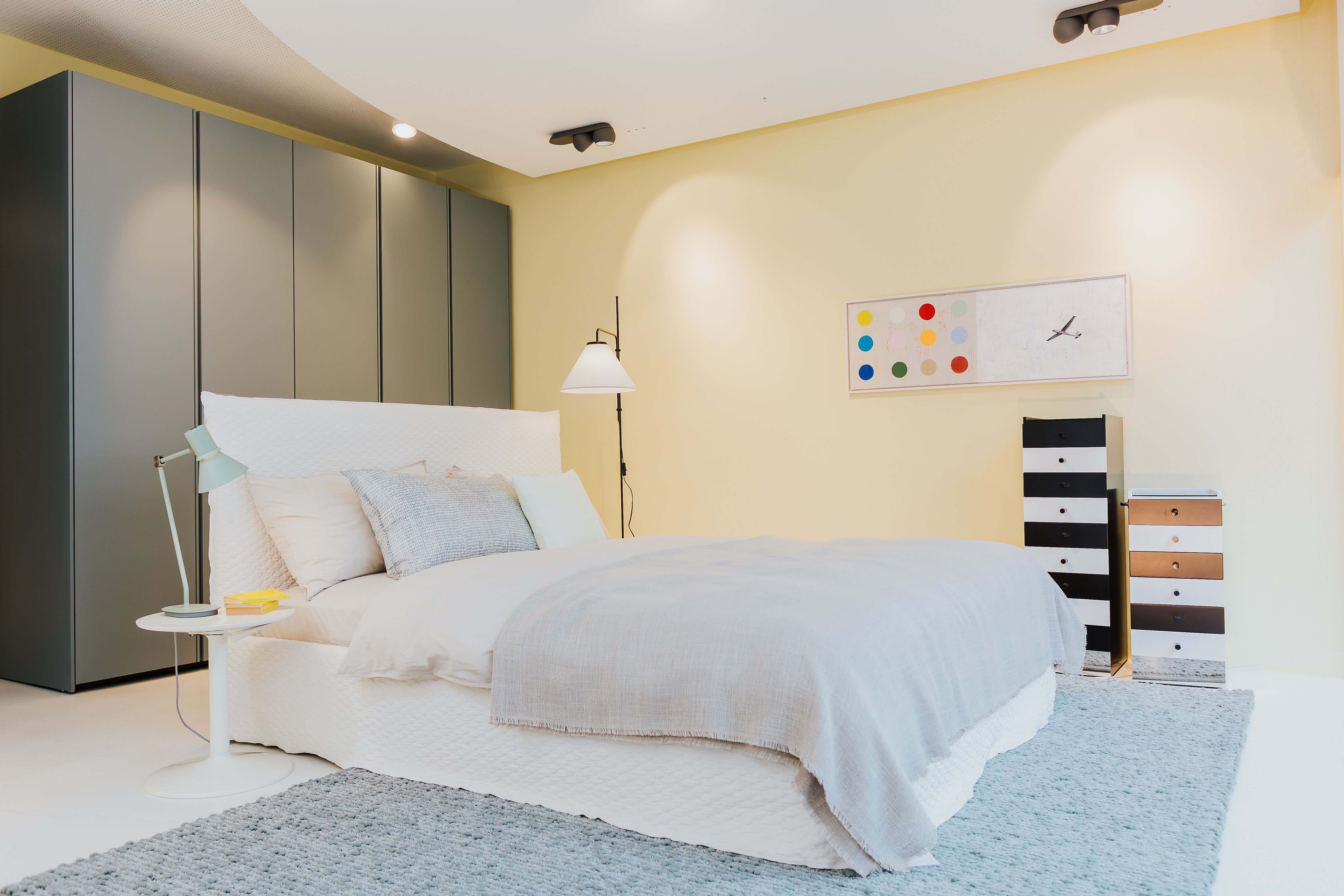 Schlafzimmer-Inszenierung mit Polsterbett, gestreifter Kommode und schlichter Farbgestaltung in Waldshut.