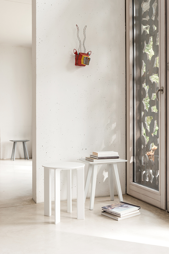 Zwei weiße Hocker von Schönbuch vor Fenster und Wand, dekorativ mit Büchern