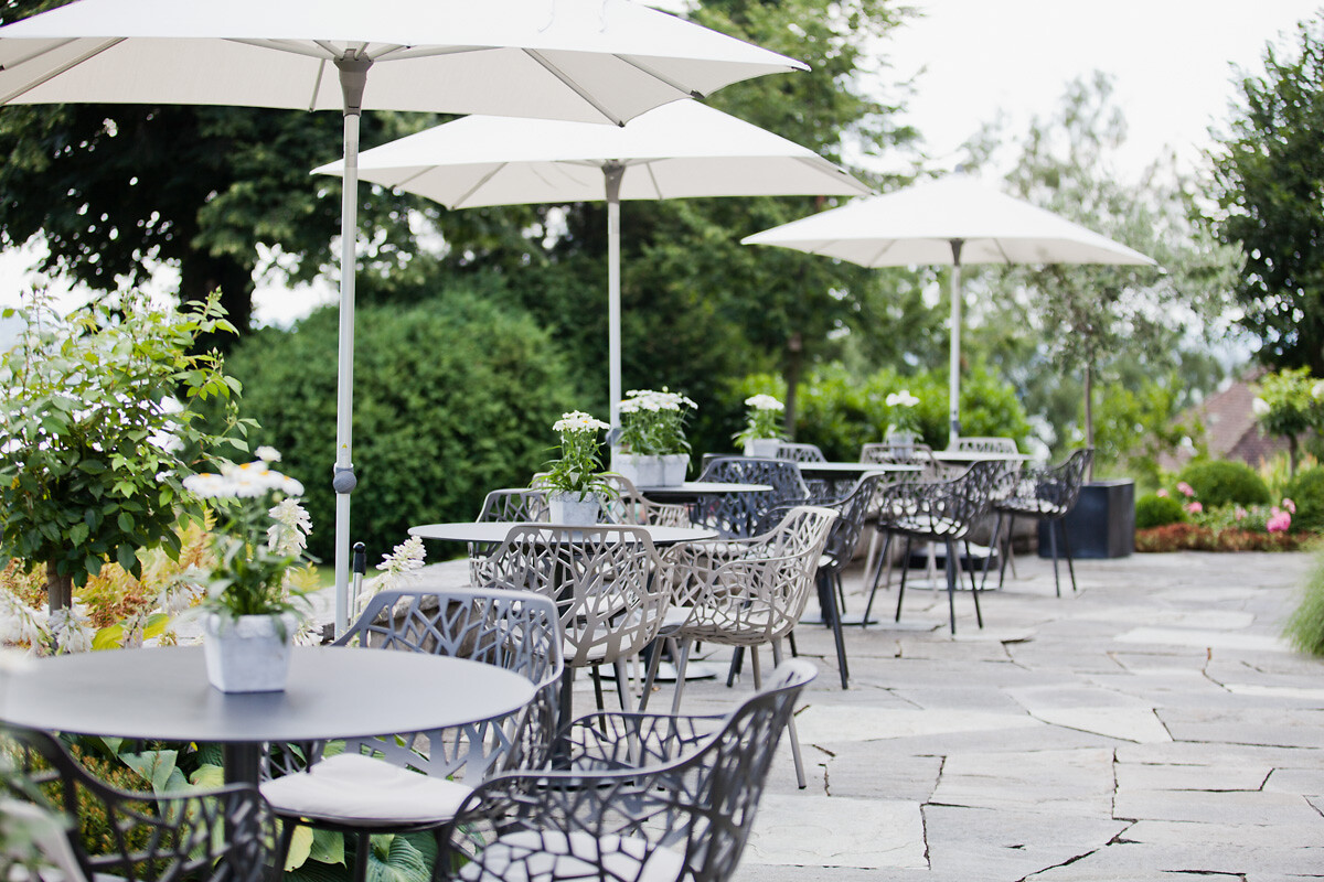 Die gemütliche Terrasse der Klinik Meissenberg lädt ein zum Entspannen und Sonne tanken in der Natur. Die Stühle und Tische für den Outdoorbereich fügen sich harmonisch in das Gesamtbild ein.