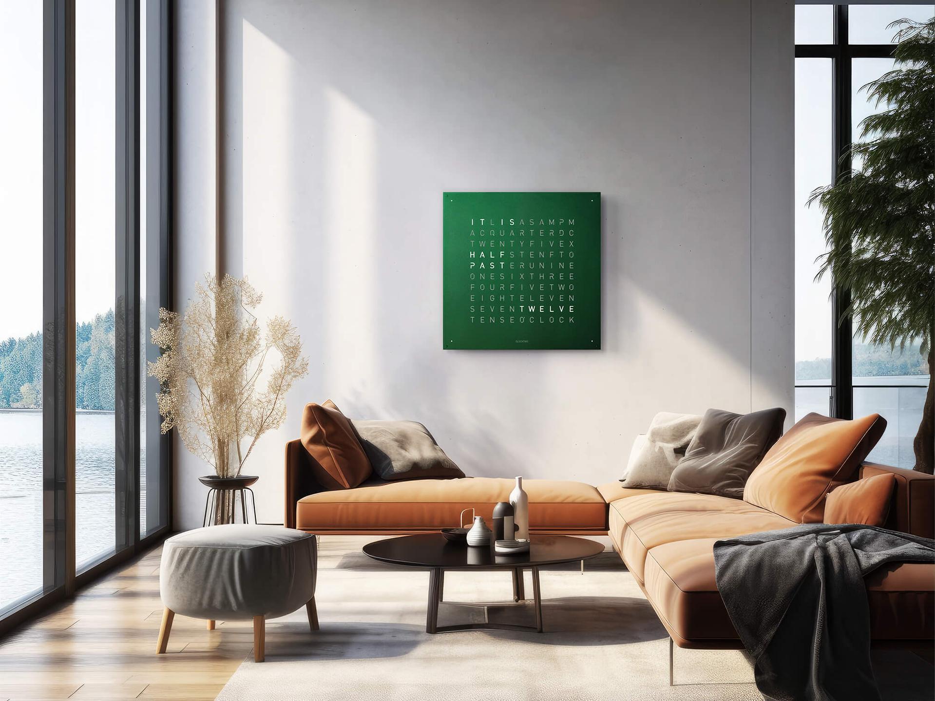 Wanduhr mit grüner Fläche und leuchtenden Buchstaben an weißer Wand in heller Wohnumgebung