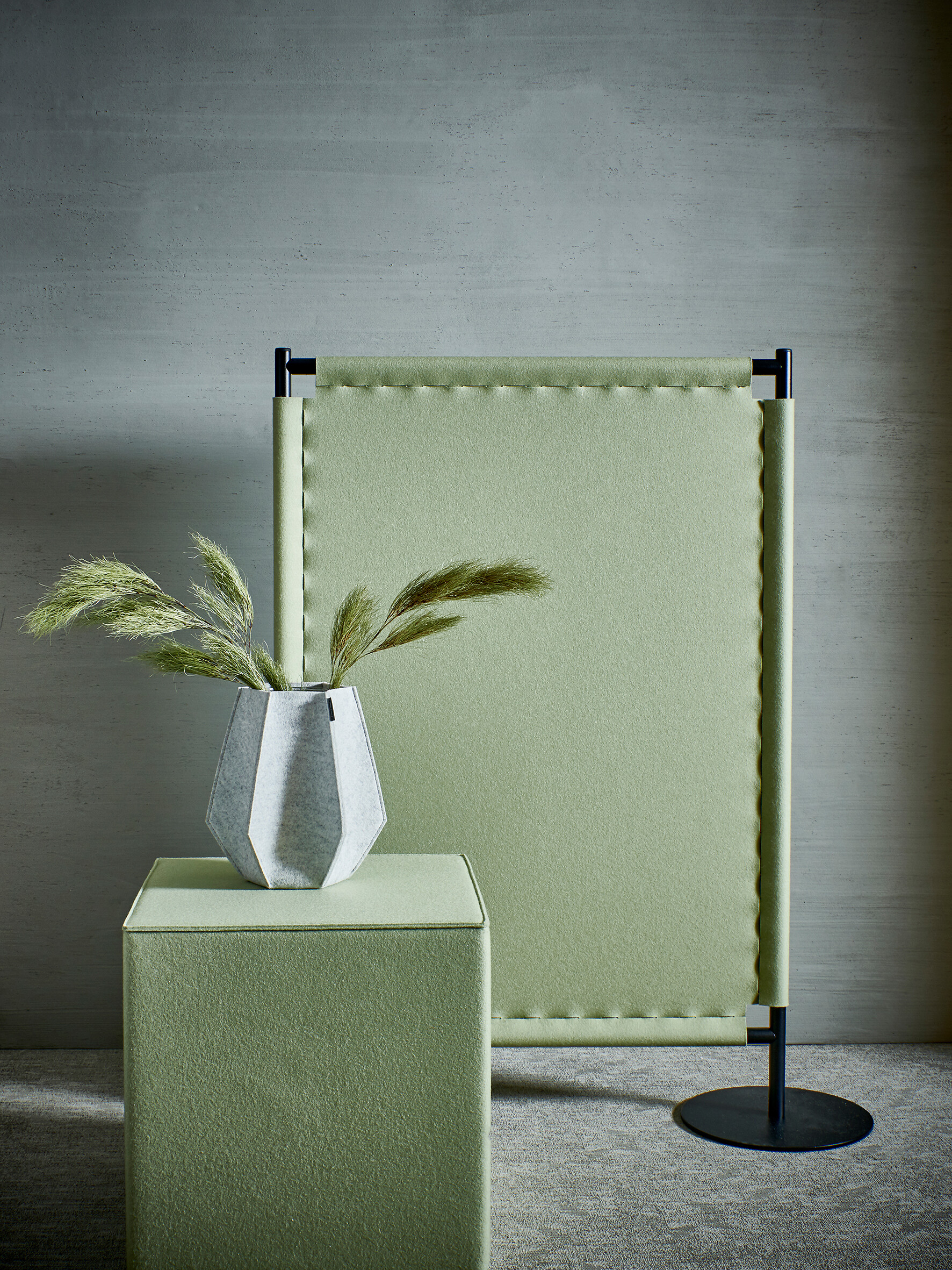 Freistehendes Filz-Akustikpaneel und Hocker in hellem Grün vor grauer Wand
