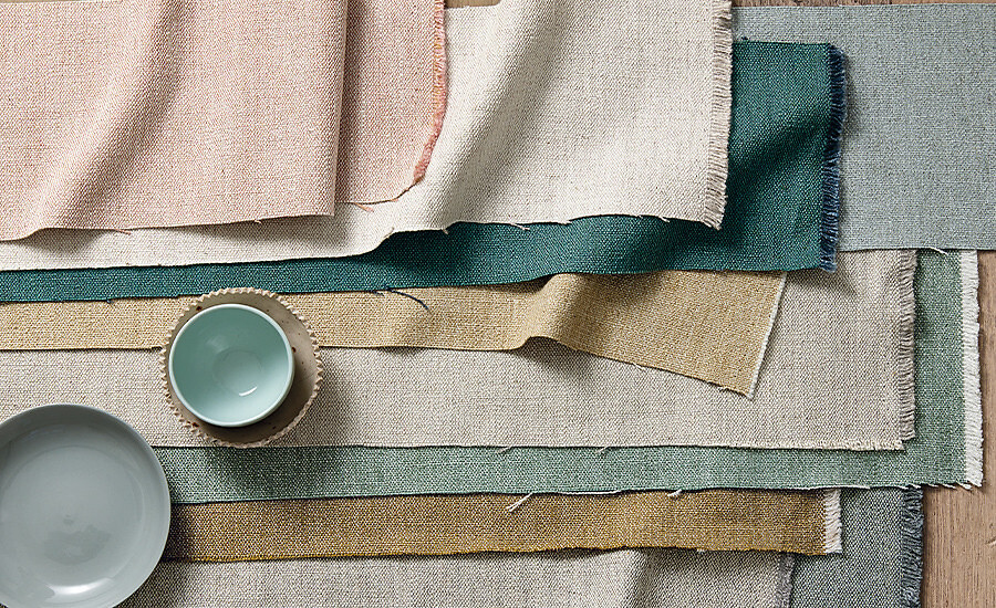 Farbige Stoffmuster in verschiedenen Strukturen und Nuancen auf hellem Untergrund