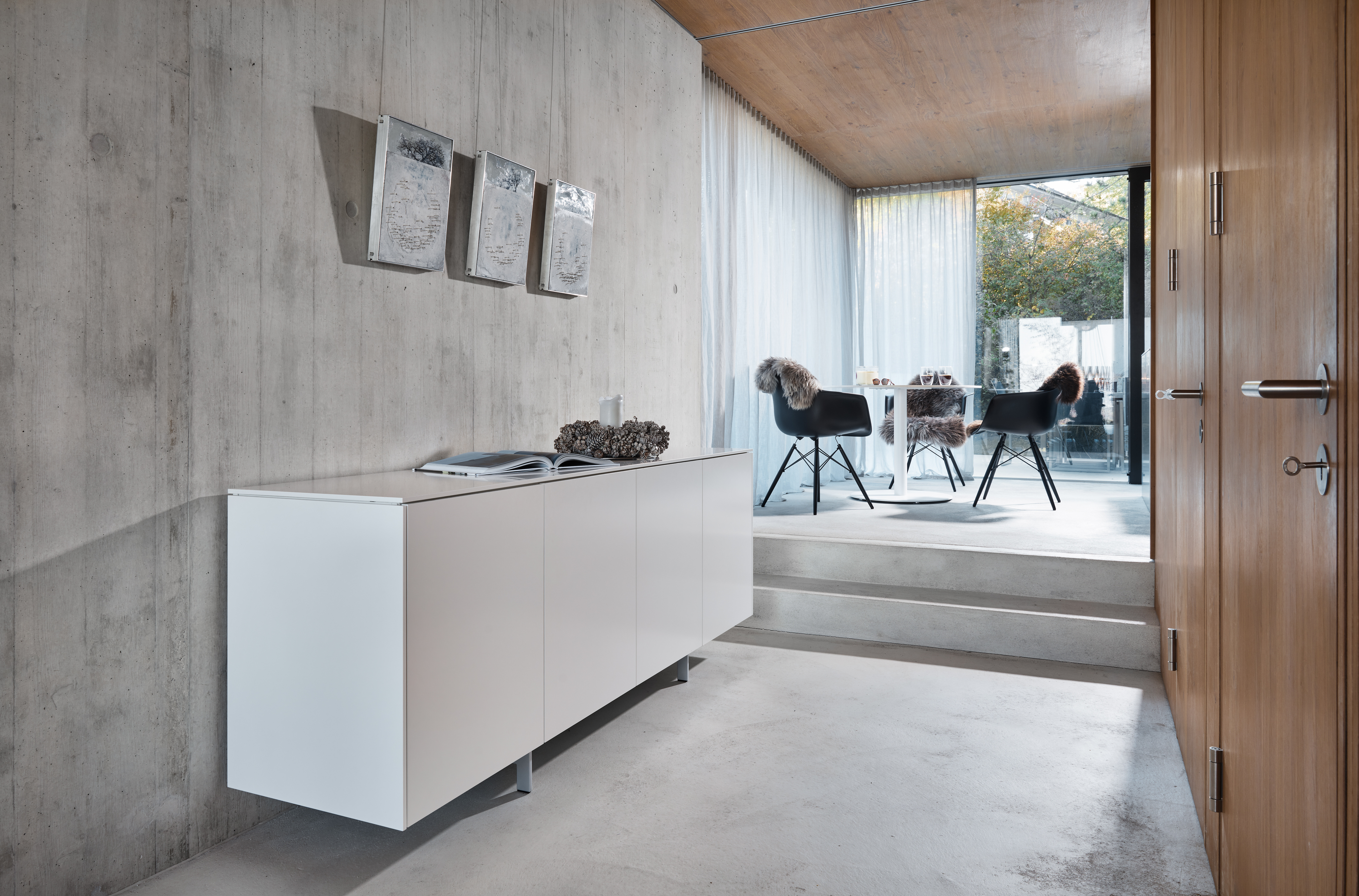 Beton, Holz und Glas bilden die Basis des modernen Neubaus. Mittelpunkt ist das offen gestaltete Erdgeschoss mit Wohn-, Koch- und Essbereich. Eine Besonderheit ist bereits von außen gut ersichtlich – das verbindende Element Eichenholz. Im Erdgeschoss zier