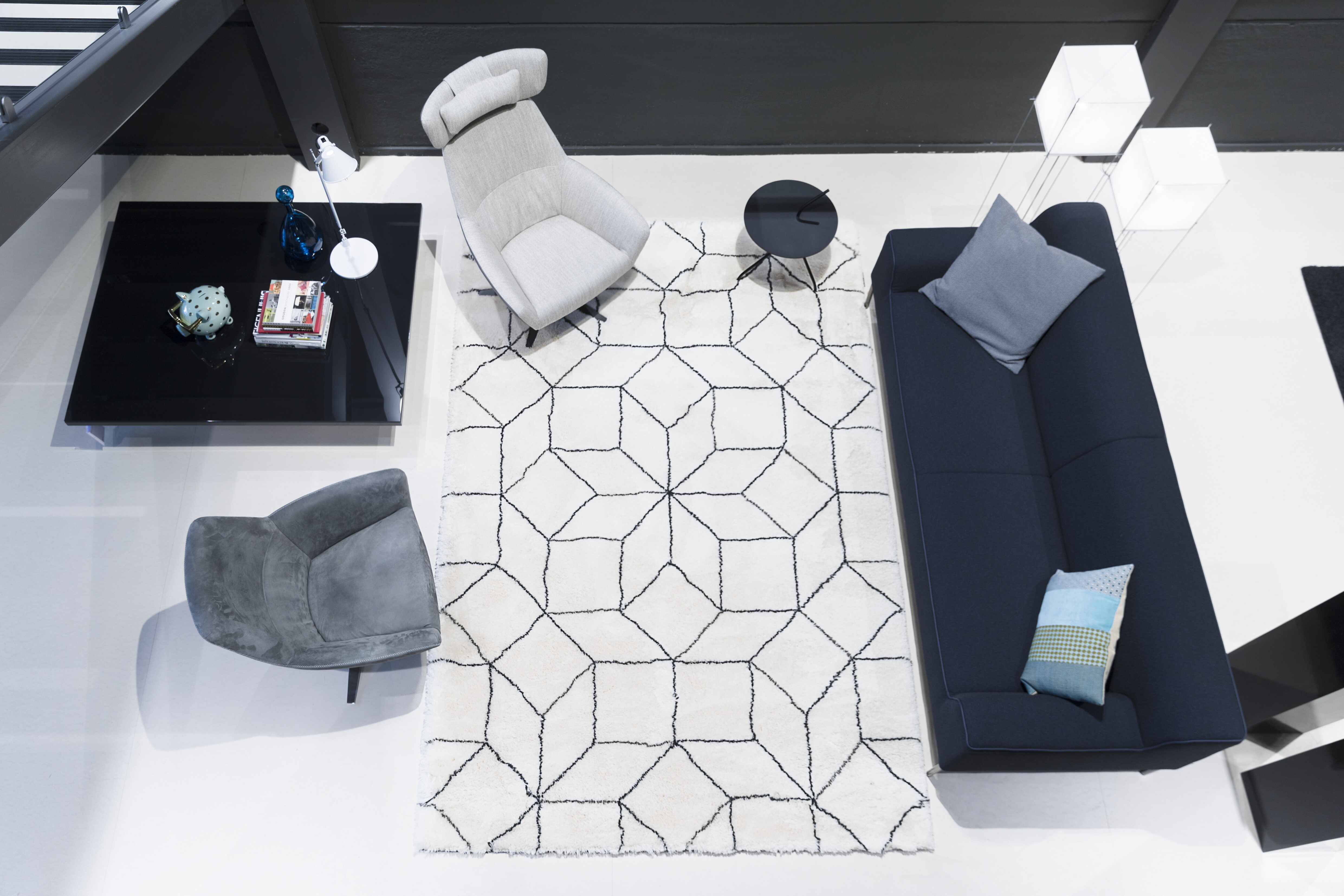 Wohnbereich mit geometrischem Teppich in Elfenbein und Dunkelblau, Vogelperspektive