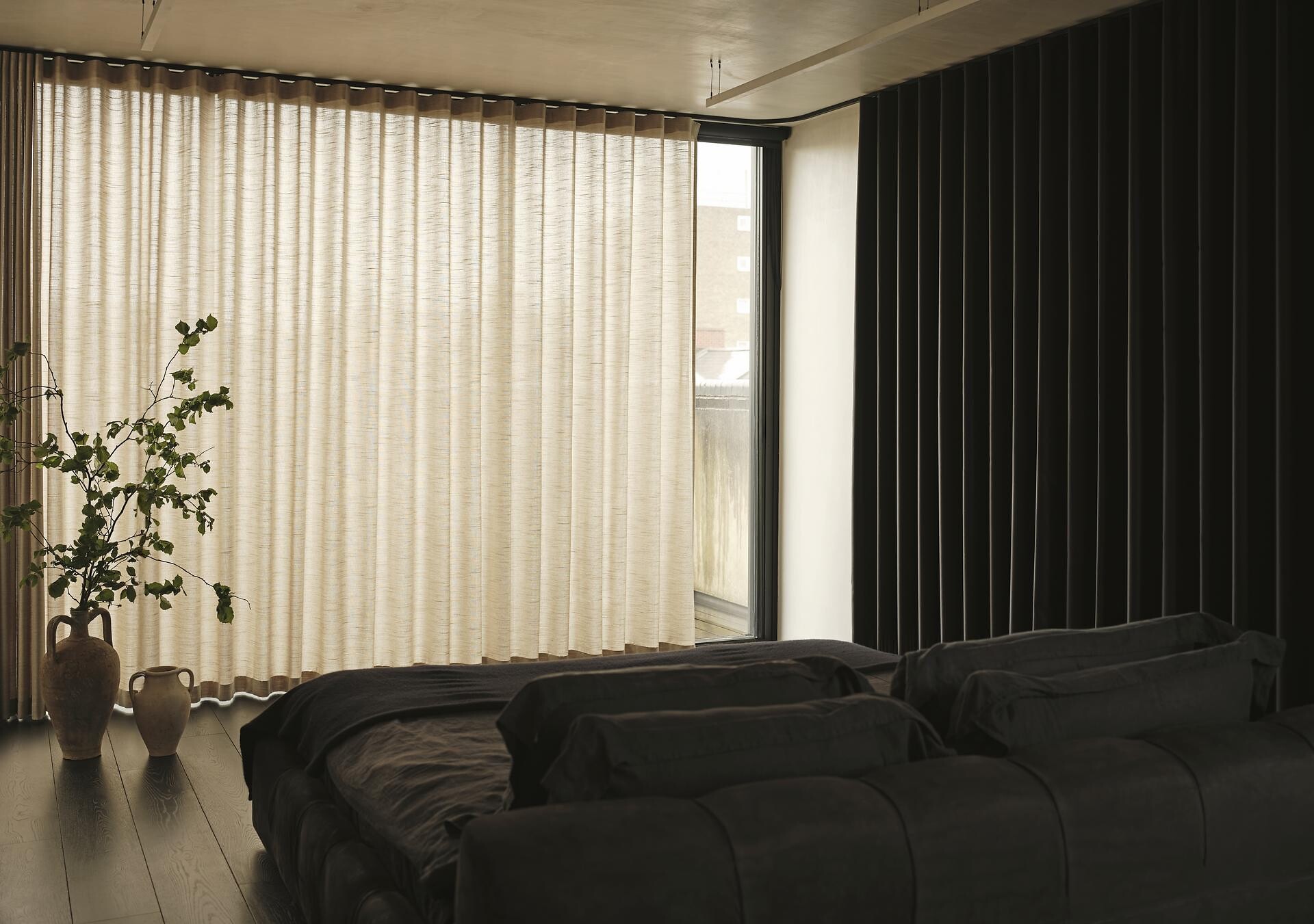 Vorhang in hellem Beigeton vor Fenster mit Verdunklungsschiene im Schlafraum